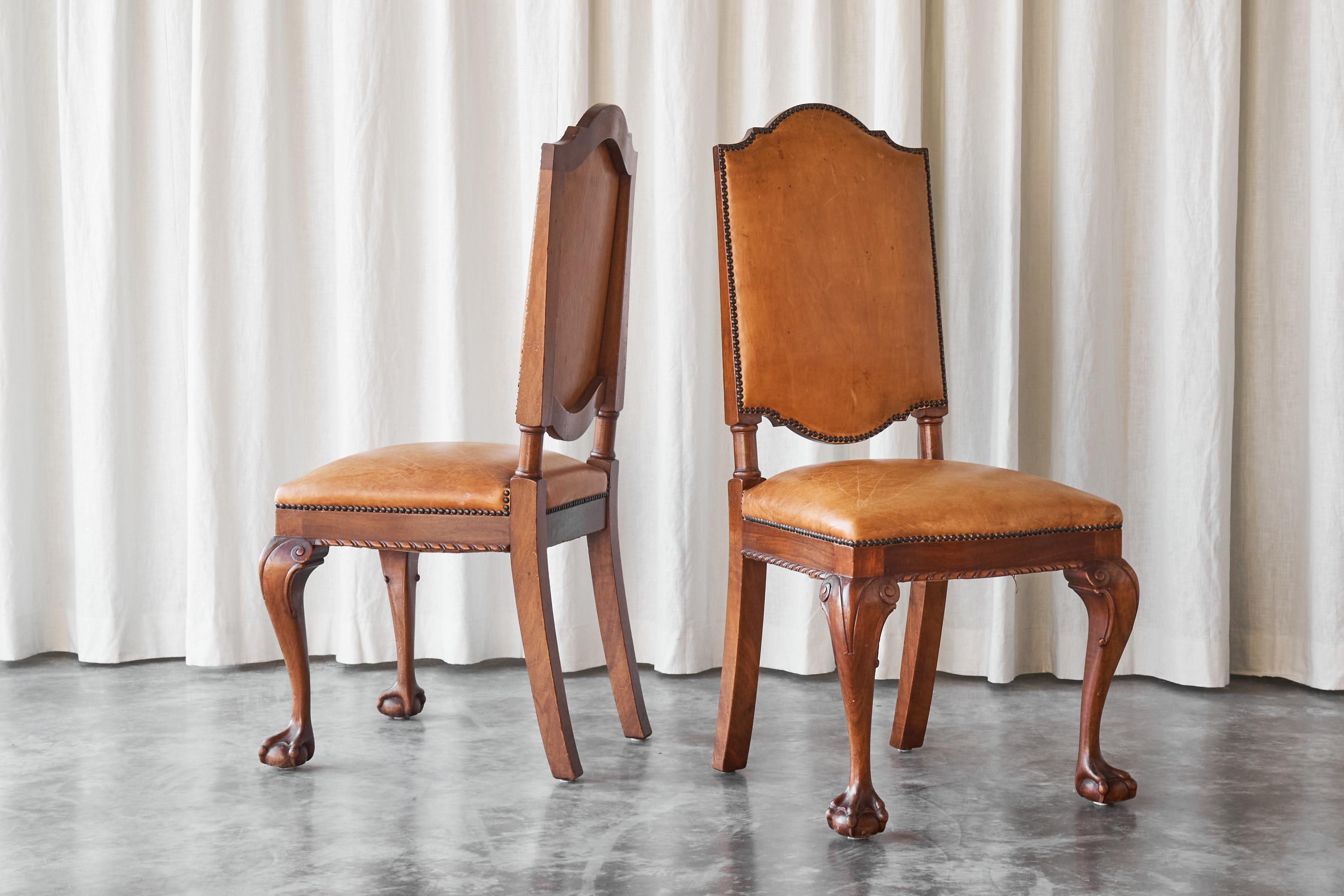 Il s'agit d'une paire très rare de chaises latérales 't Woonhuys Amsterdam en cuir cognac patiné très désirable, fabriquées dans les années 1920.

Au début du XXe siècle, 't Woonhuys, à Amsterdam, était l'entreprise de meubles la plus illustre de