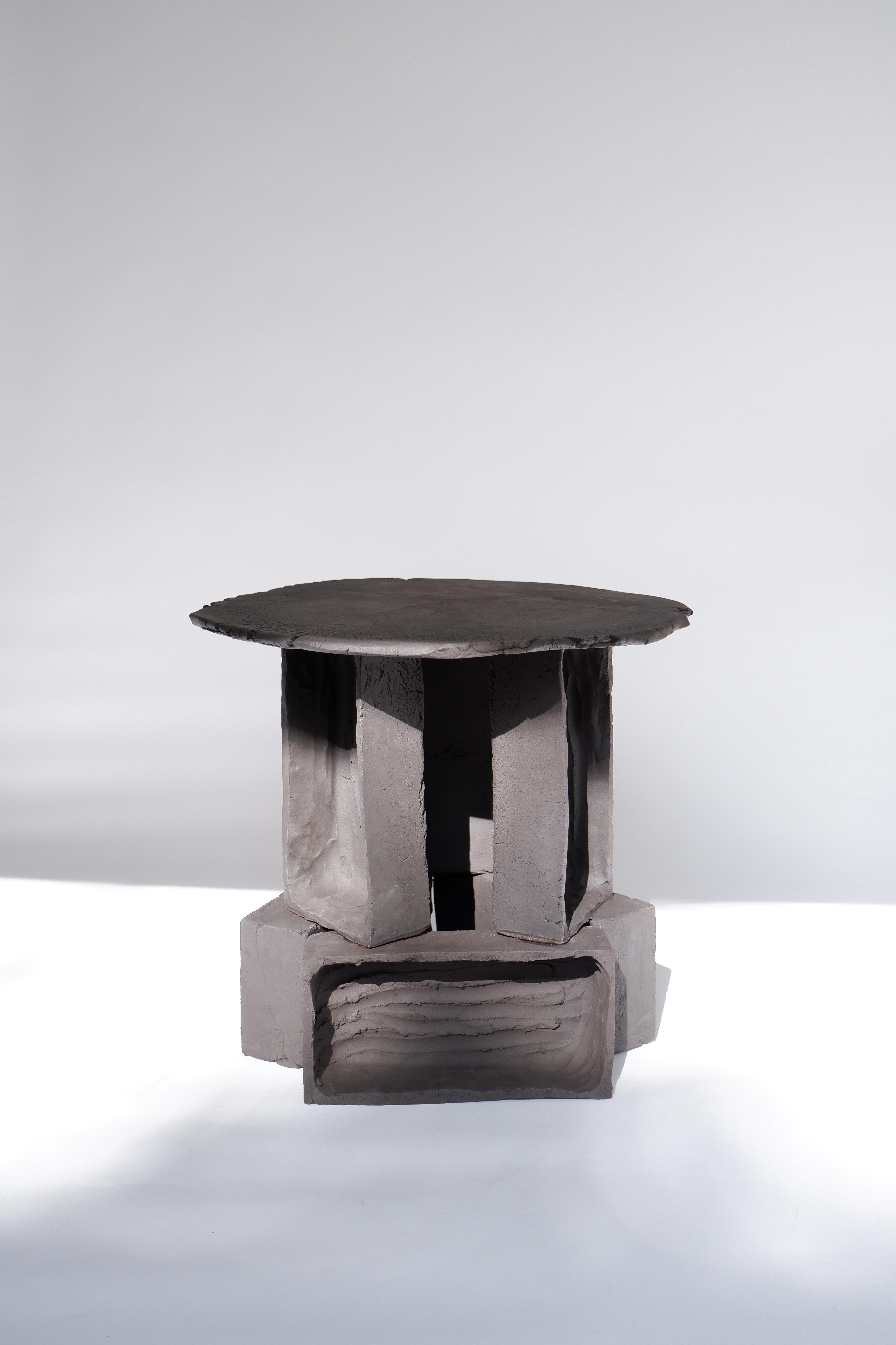 T02 Coffee Table by Ia Kutateladze
One Of  A Kind.
Dimensions: D 38 x H 37 cm.
Materials: Black clay.

Each piece is one of a kind, due to its free hand-building process. The top is always irregular and one of a kind. Possible material variations:
