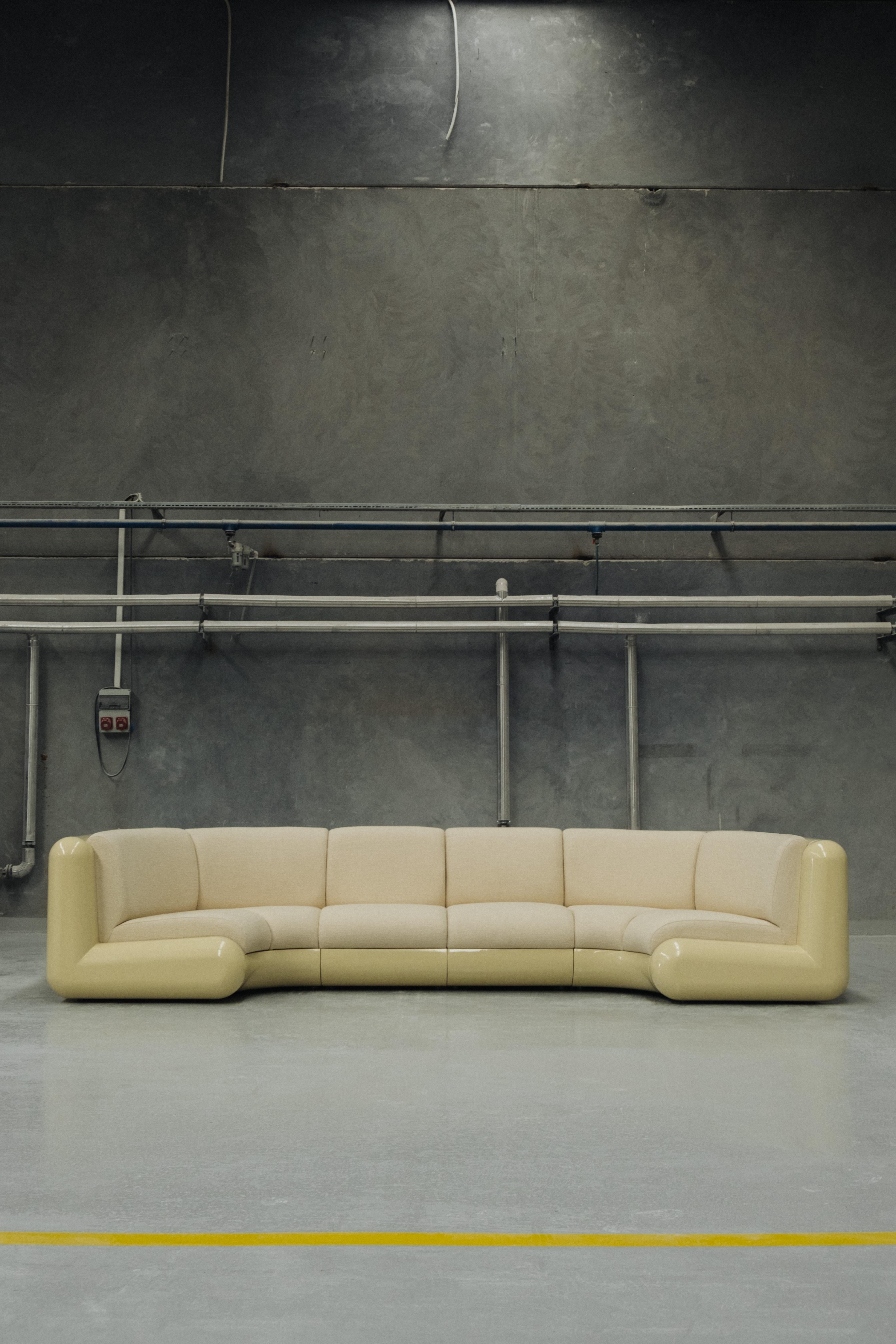 The T4 Corner Sofa designed by Holloway Li for Uma is a robust fiberglass three-seater with cream bouclé textured fabric upholstery. 
Uma’s T4 collaboration with Holloway Li was unveiled in 2022. The playful design of the T4 invites us to take a