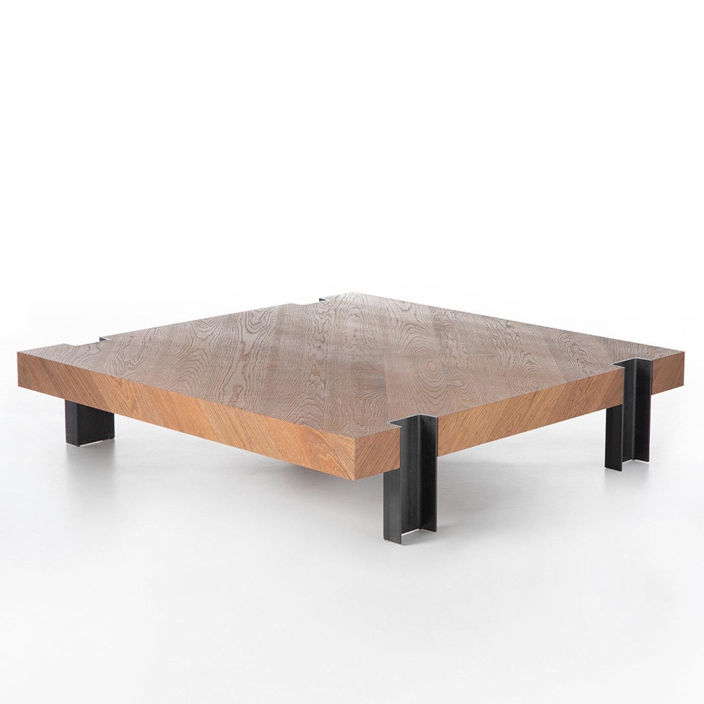 The impactful note distinguishing this extra-low coffee table lies in its solemn aesthetic, where the metal legs appear recessed into the square, ultra-thick wooden top without joints. Deceptively rigorous at first sight, the design channels a
