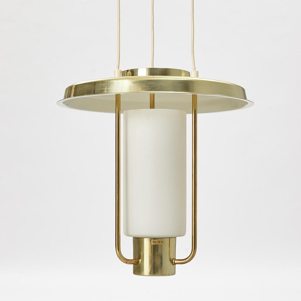 La lampada a sospensione T825, disegnata da Hans-Agne Jakobsson negli anni '60, è caratterizzata da un'estetica minimalista e da un'eleganza senza tempo. La sua struttura in ottone e le finiture raffinate mettono in risalto il paralume in vetro