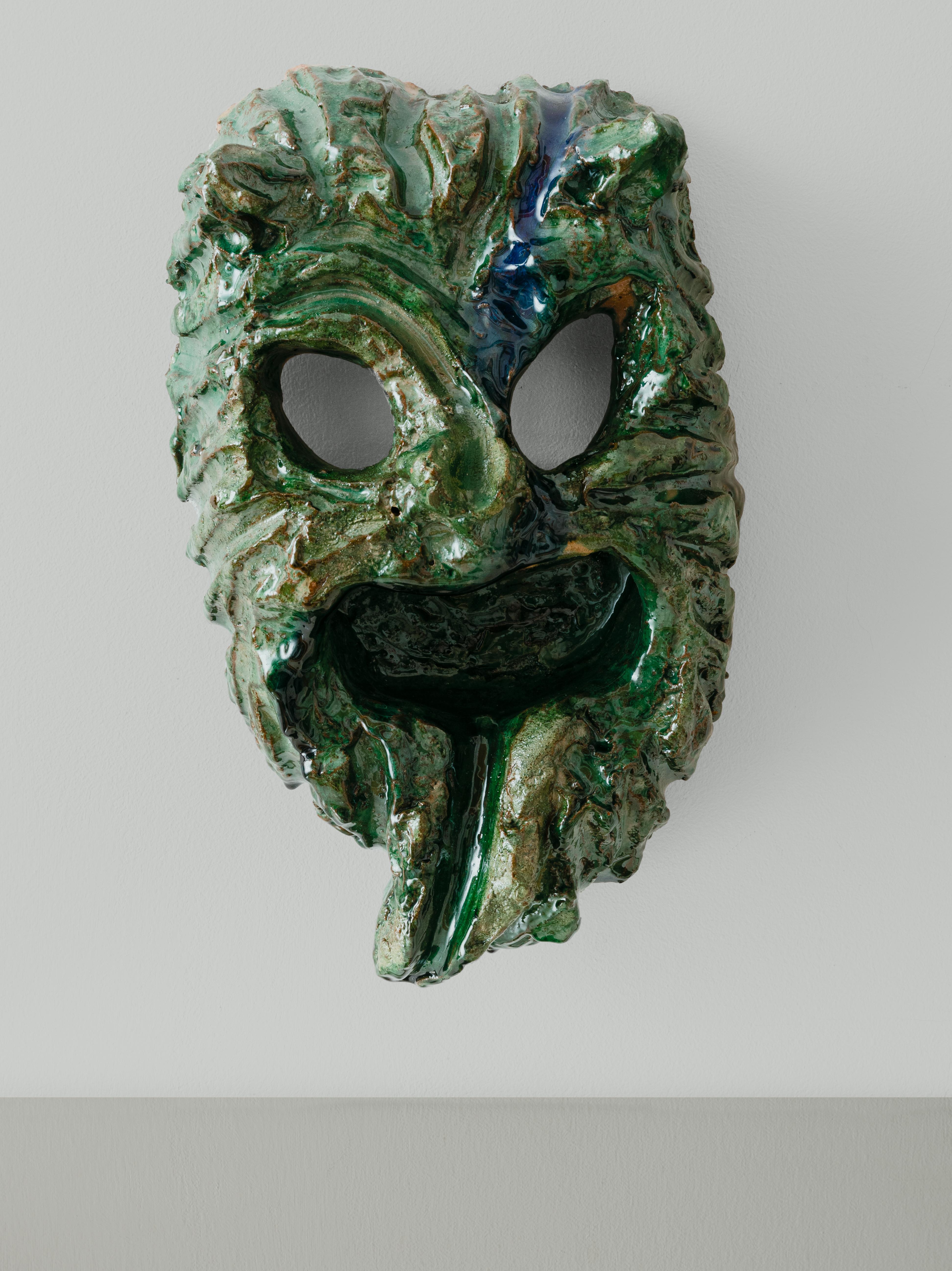 The apotropaic (warding off evil) mask from Seminara can be distinguished by its horns, wide eyes, mustache, and screaming mouth with its tongue sticking out. The masks are finished in enormous wood fired kilns, which adds an uncontrollable twist to