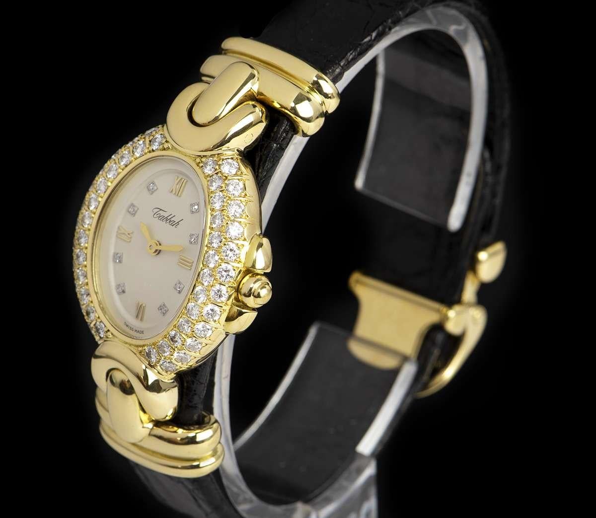 An 18k Yellow Gold Diamond Set Vintage Ladies Wristwatch, silver dial set with 8 applied diamond hour markers and applied roman numerals at III, VI, IX and XII, a fixed 18k yellow gold bezel set with approximately 50 brilliant round cut diamonds