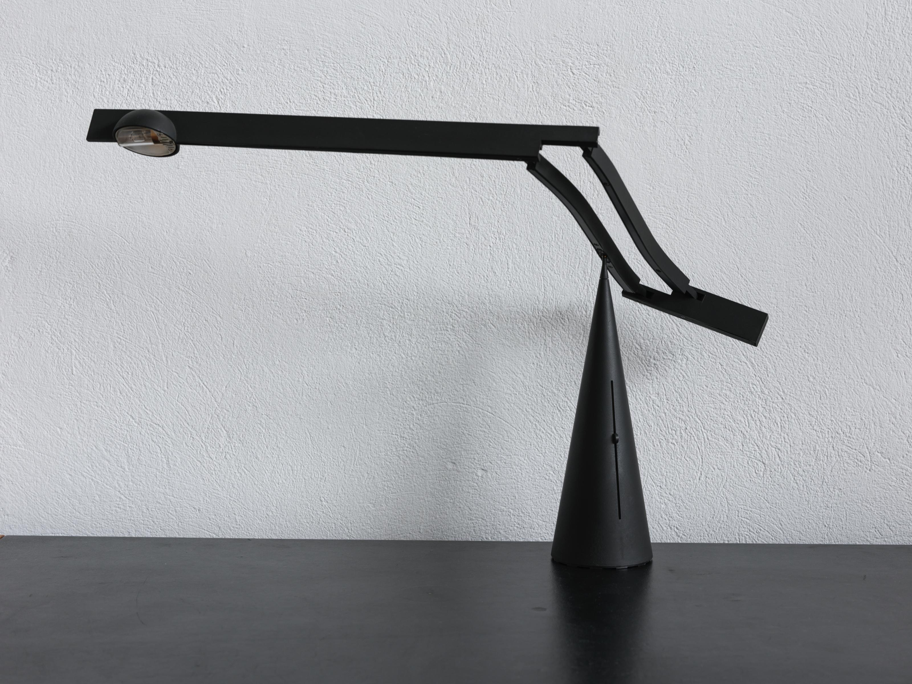 Tischleuchte Tabla von Mario Barbaglia & Marco Colombo für Italiana Luce, 1988.
Tabla hat einen ausziehbaren, verstellbaren Arm aus leichtem Polykarbonat-Kunststoff, der sich an der Spitze eines konischen Aluminiumsockels dreht. Der Transformator