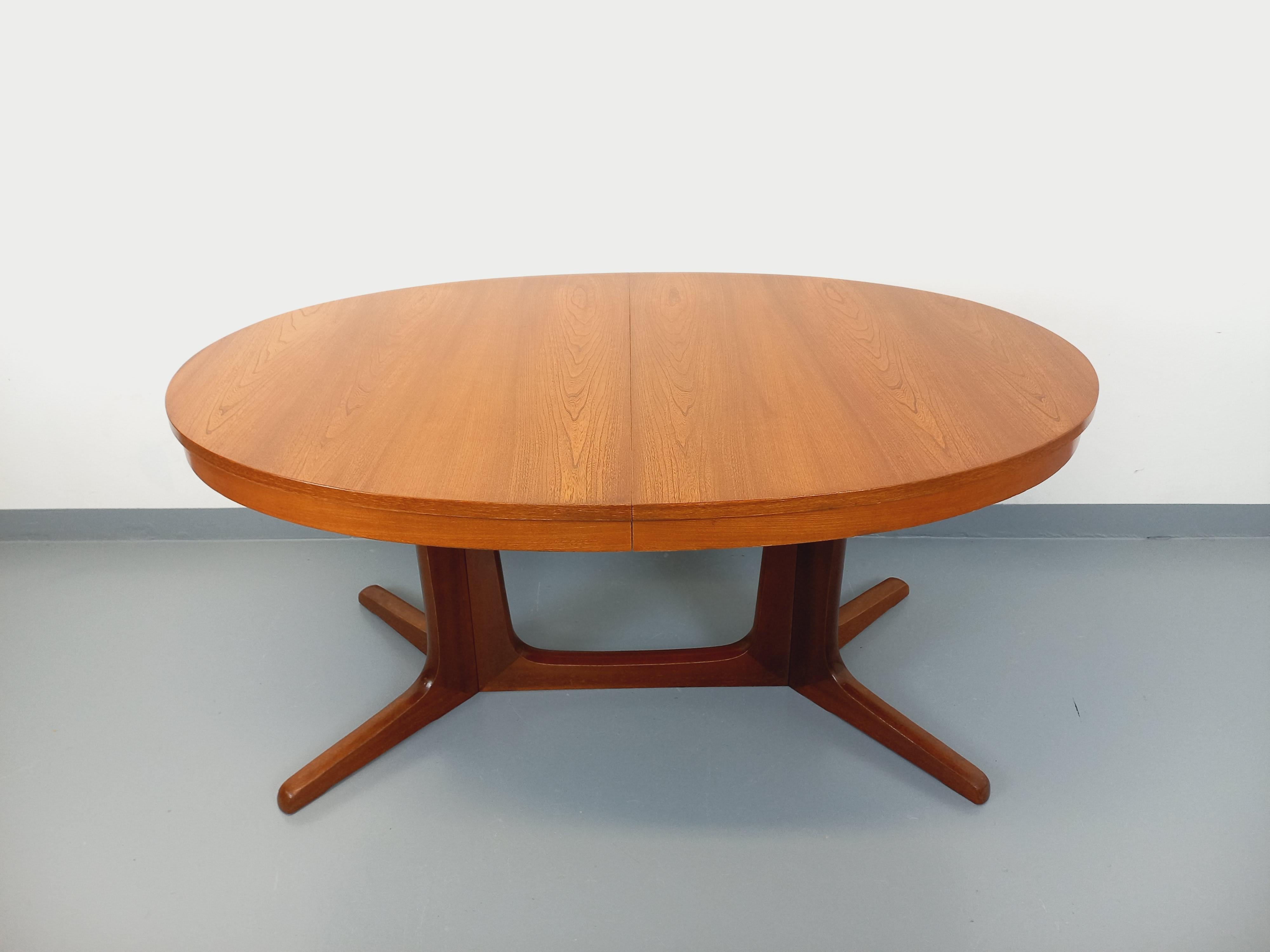 Table à manger vintage des années 60 70, de la manufacture française Baumann, de style scandinave et de forme ovale, beau plateau en orme, 2 pieds centraux à 4 branches. La table s'ouvre par le centre pour accueillir deux rallonges en orme non
