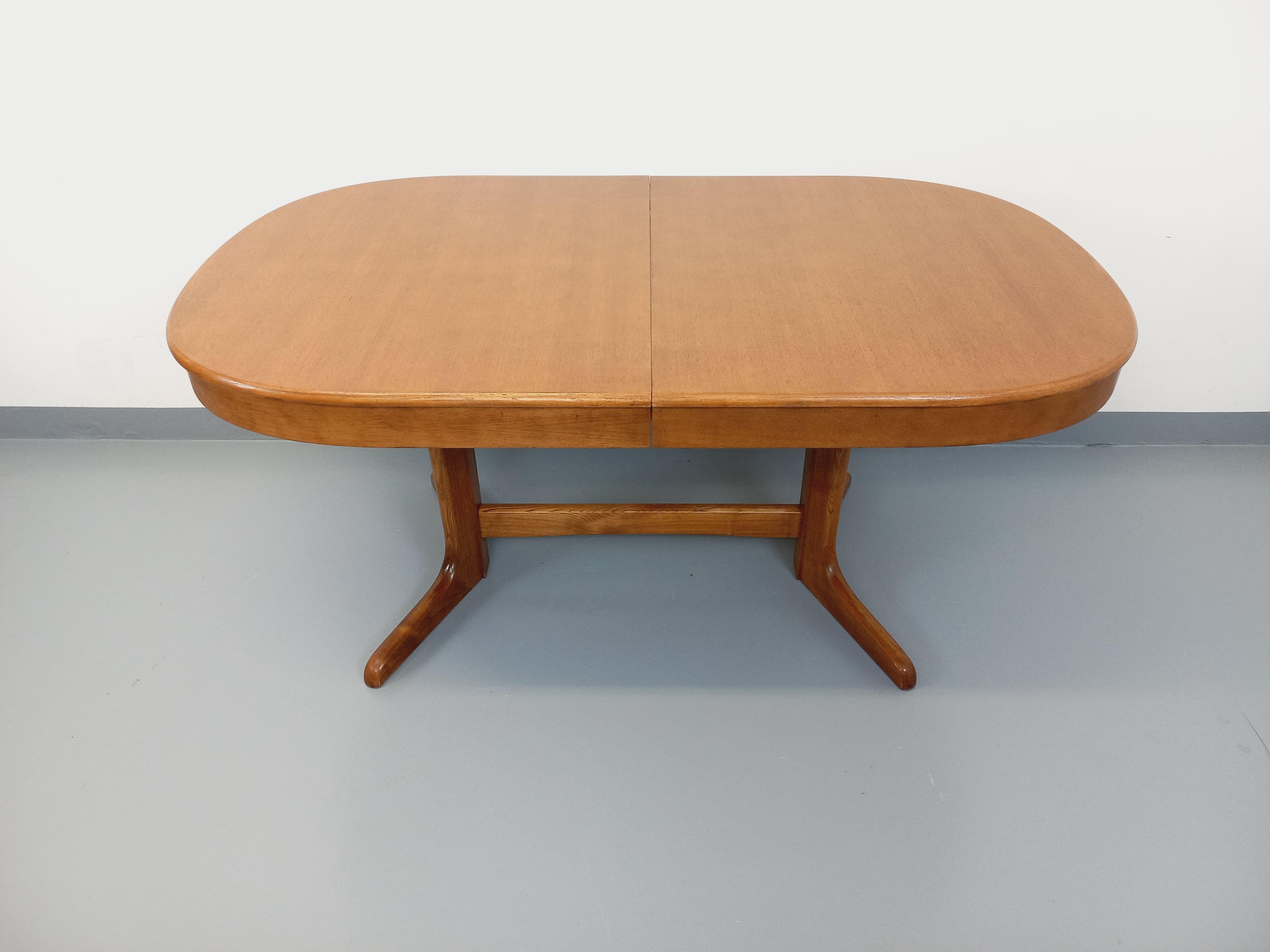 Table à manger vintage des années 60 70, style scandinave, plateau ovale en bois de chêne, superbe double pied central à 4 branches en orme. La table s'ouvre par le centre pour accueillir jusqu'à 4 rallonges (intégrées dans un coffre au centre de la