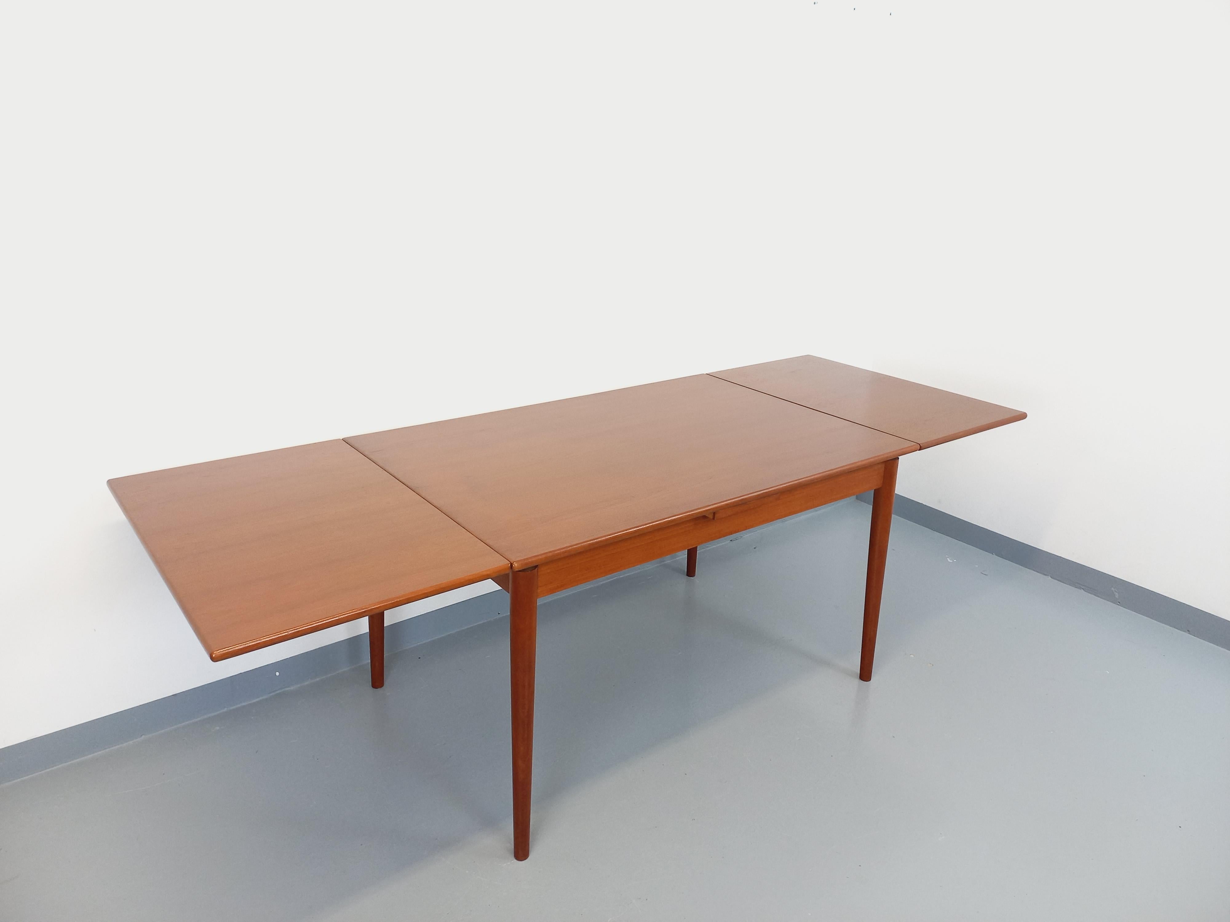 Très belle table à manger rectangulaire vintage de style scandinave des années 50 60, en teck, plateau rectangle aux bords doux et arrondis, avec deux rallonges intégrées aux extrémités, pieds compas, format rare parfait pour une petite ou moyenne
