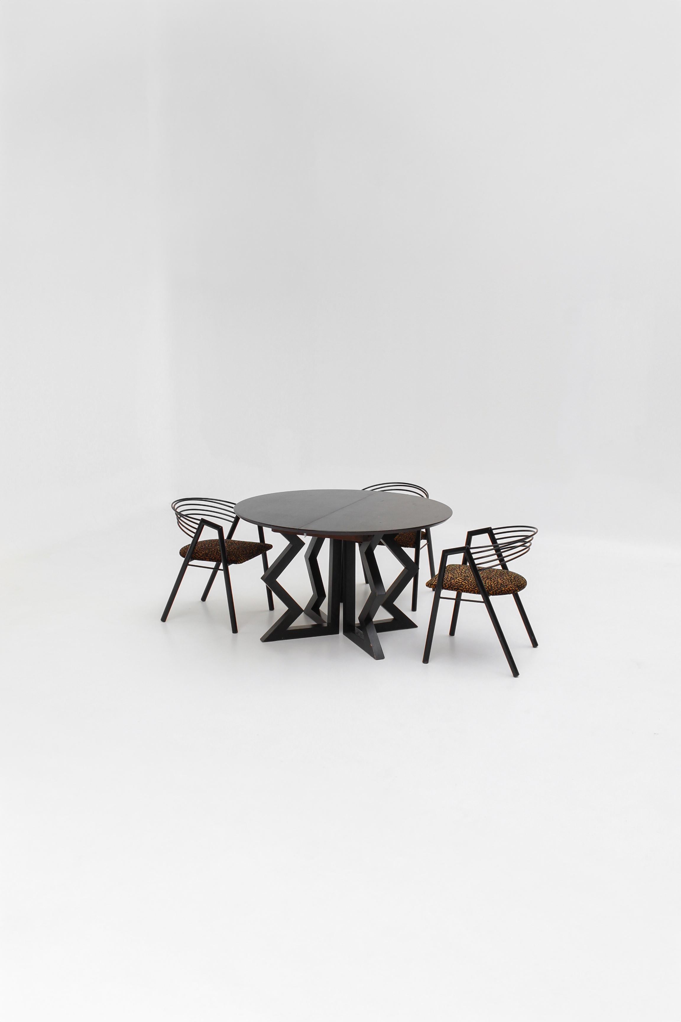 Imaginée par Gene Summers pour Artelano dans les années 1990, la table incarne la rencontre entre architecture moderniste et influences primitives.

Réalisée en bois de wengé brun et noir, elle dégage une présence sculpturale et intemporelle.

Son