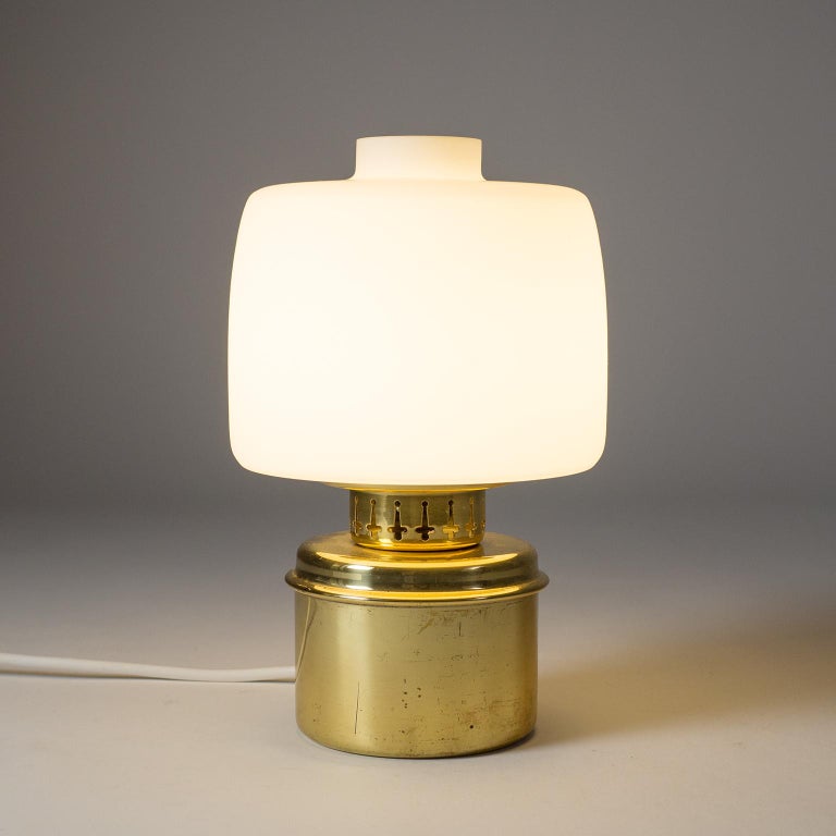 Fine brass and satin glass table and wall light by Hans-Agne Jakobsson, circa 1960. The design is a modernist variation on classical oil table lamps. This one comes with a rare original wall mount into which the lamp can be inserted to be used as a
