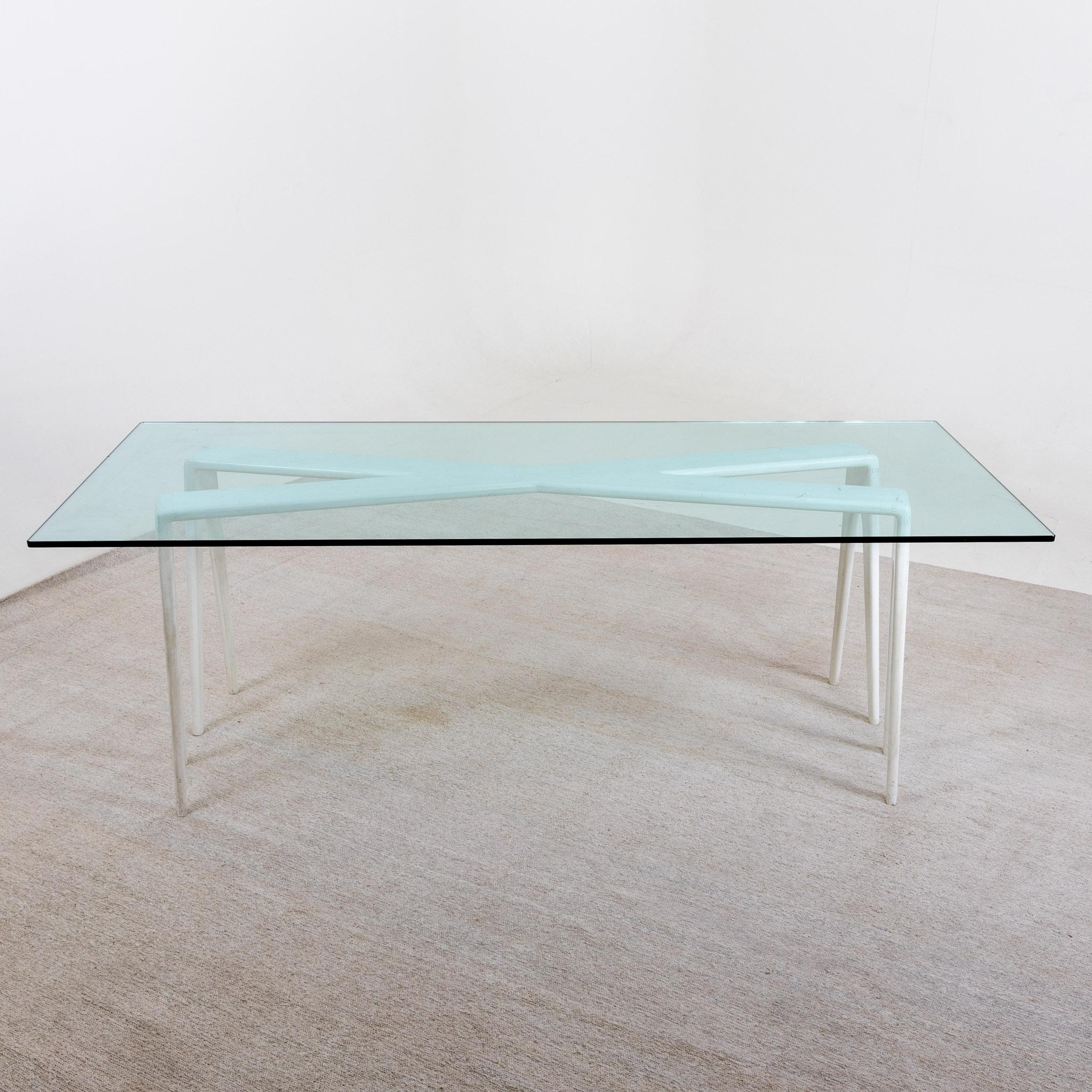 Großer Esstisch mit rechteckiger Glasplatte auf x-förmigem, weiß lackiertem Holzgestell. Leichte Alters- und Gebrauchsspuren.