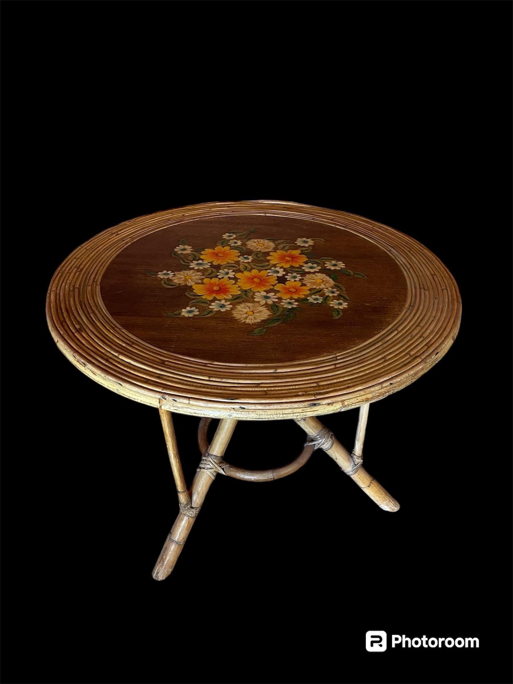 Table ronde en bambou et rotin de la Côte d'Azur exceptionnelle par sa taille et ses fleurs originales peintes. Méditerranée, vers les années 1960.

Cette table centrale ronde méditerranéenne aux délicates fleurs peintes présente un cadre rond en