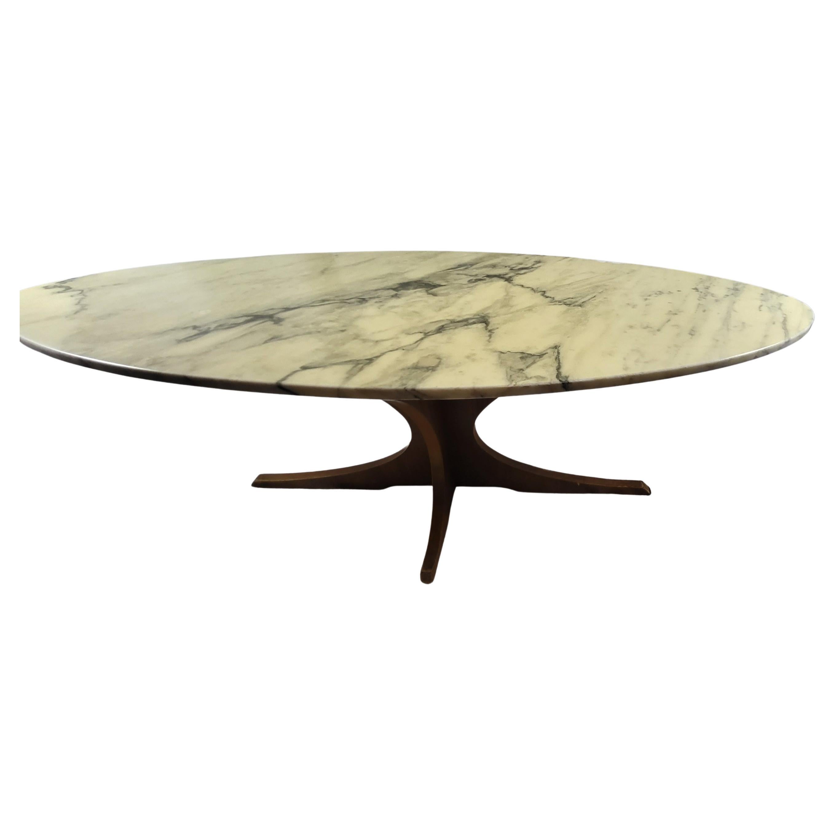Table basse vintage 1960, avec plateau  ovale, forme planche de surf, en marbre veiné, amovible, piétement croisé en bois massif.
Le vernis pour protéger le marbre est usé sur le coté (voir la photo) il suffit d'enlever ce vernis pour voir