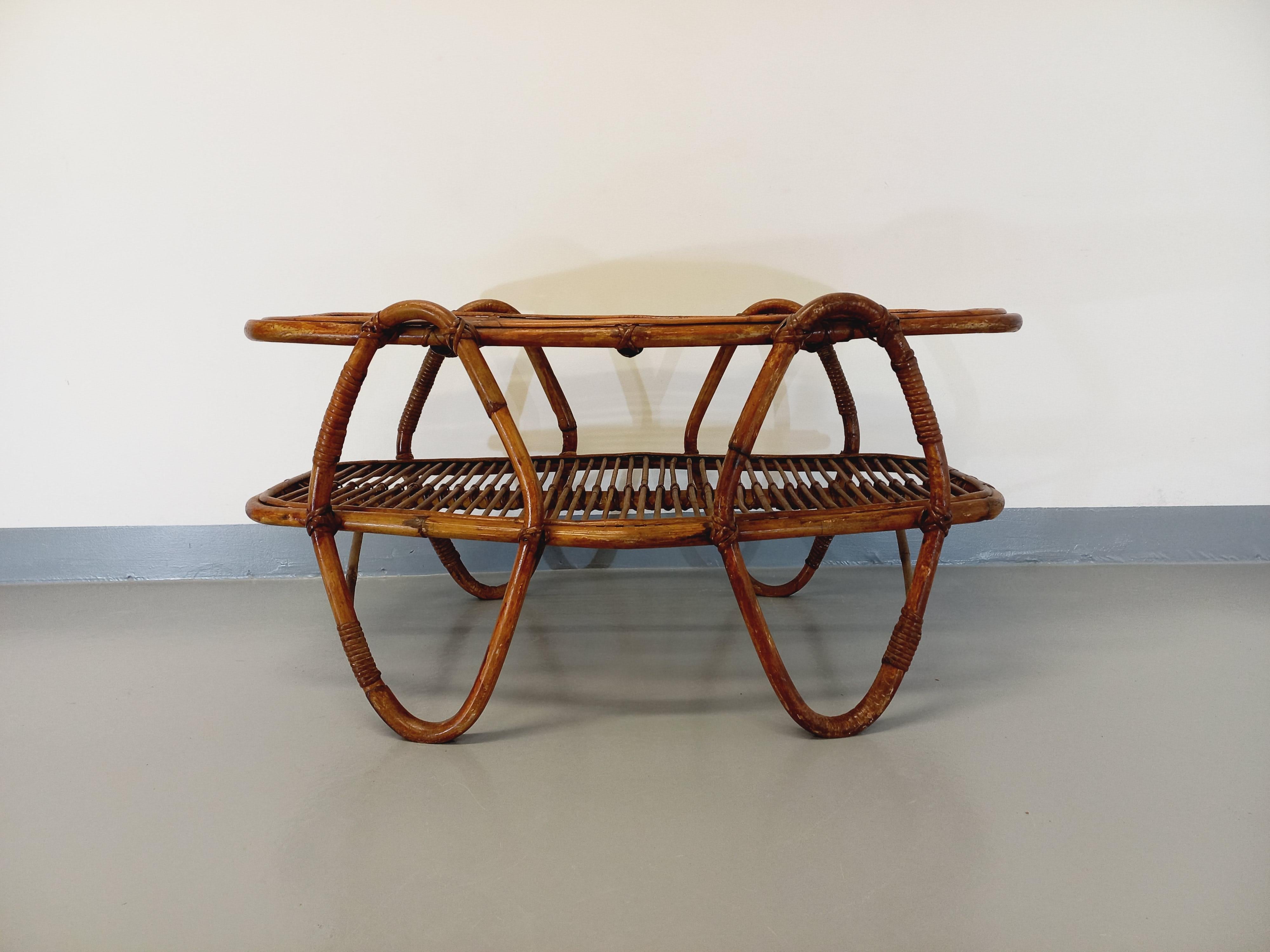 Table basse vintage des années 60, en rotin, avec plateau porte-revue intégré, design italien, modèle original et rare. Très bon état général, avec le charme et la patine du temps qui passe, pas de manque au niveau du rotin, l'ensemble a été reverni
