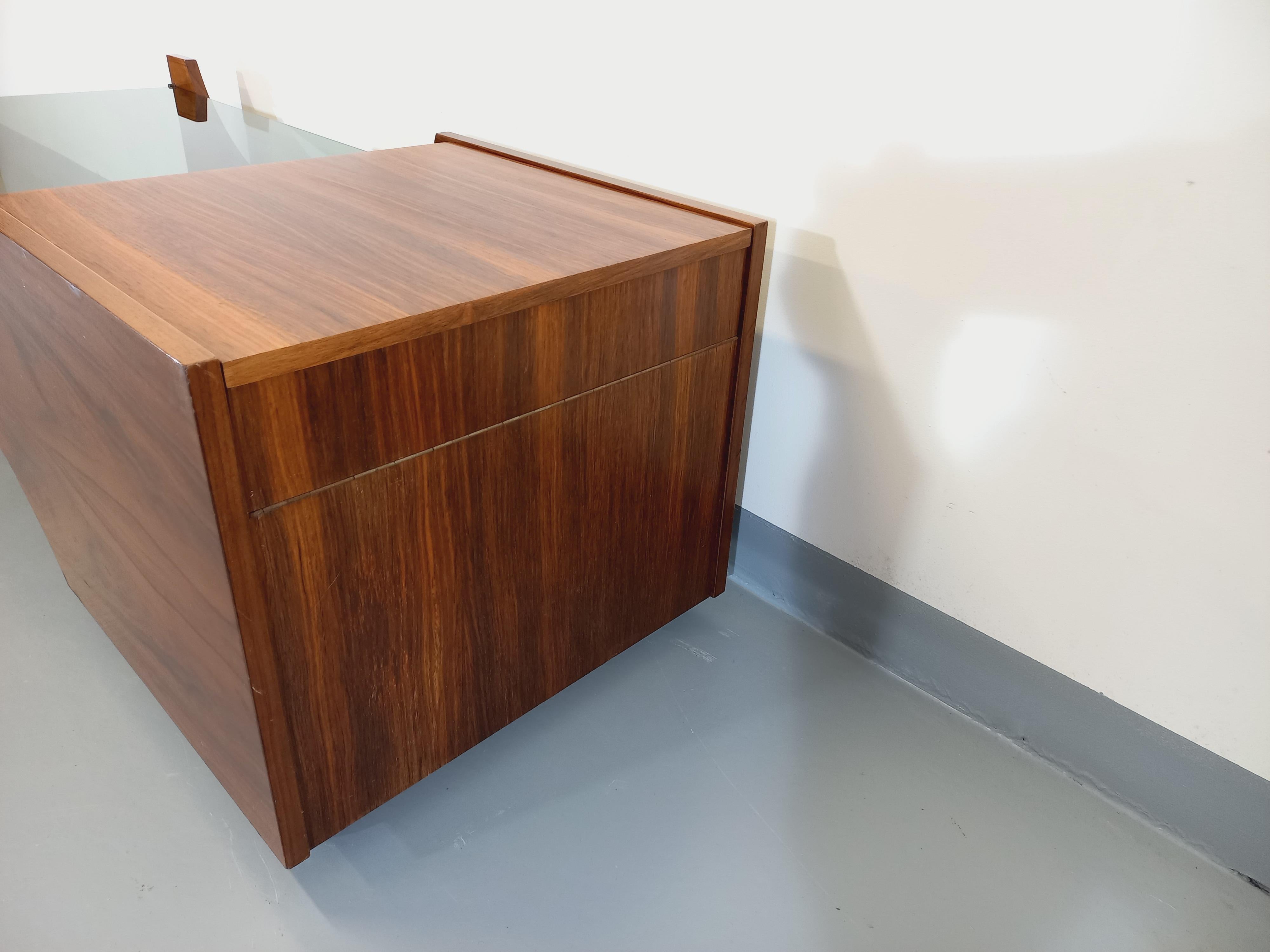 Table basse rectangulaire vintage des années 60, en palissandre, sur roulettes, partie bar intégrée dans un coffre, plateau porte-revue, plateau en verre fumé rectangle, beau design italien, modèle original et rare, très bon état général.
Ref 221