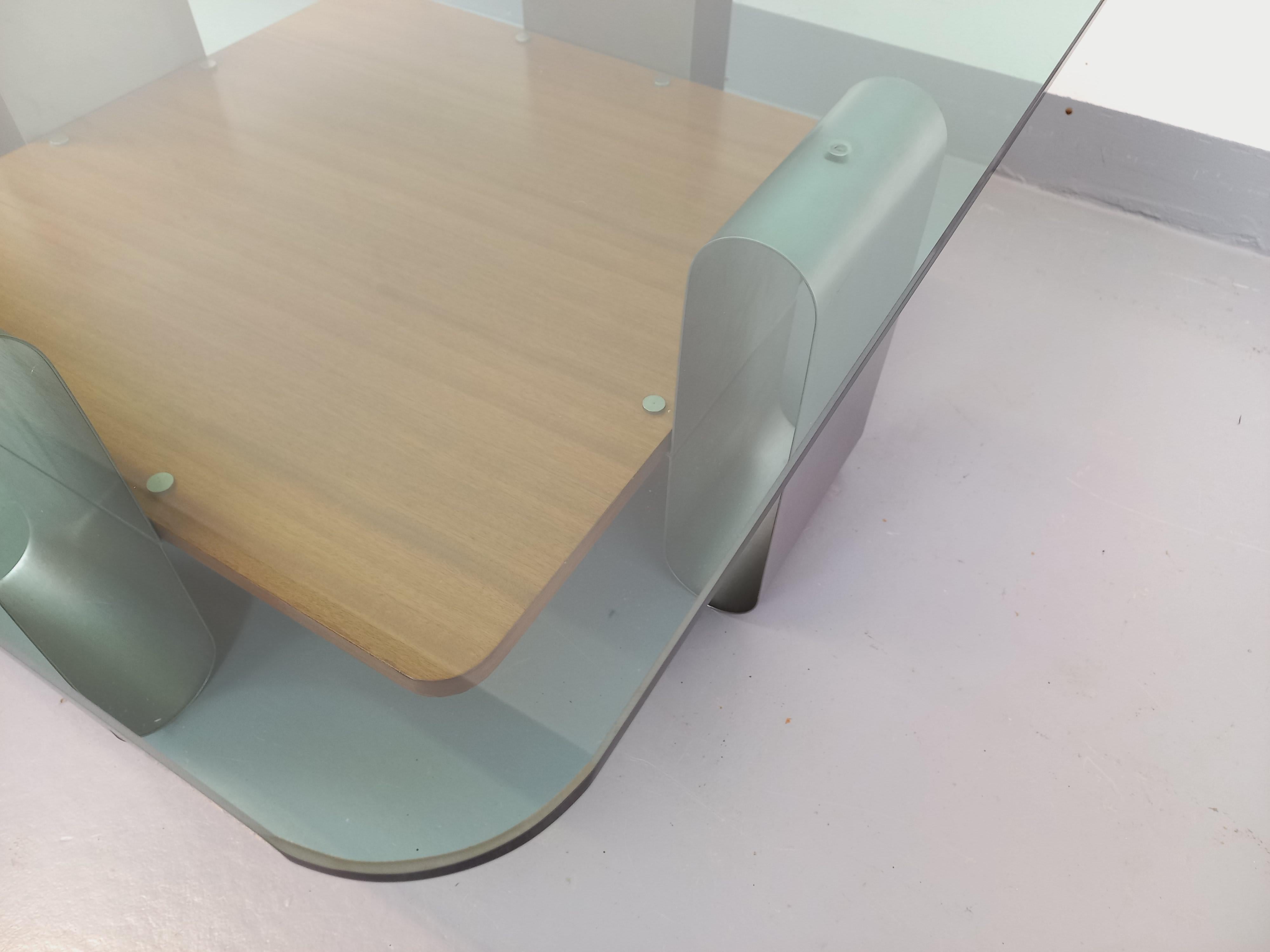 Table basse à 2 plateaux vintage des années 70, rare modèle au très beau design style Space Age, dans le goût de François Monnet, plateau supérieur en verre légèrement bleuté carré aux angles arrondis, plateau inférieur porte-revue carré aux angles