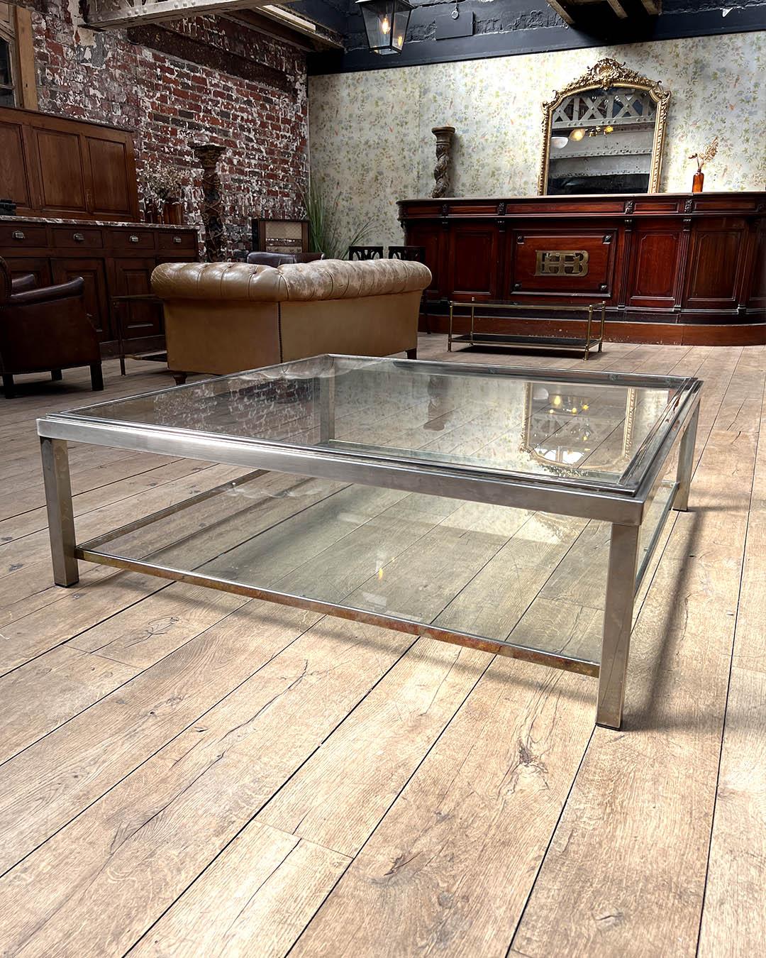 Elegante e icónica mesa de centro cuadrada del renombrado diseñador italiano Romeo Rega, de la década de 1970. Esta pieza presenta una estructura de acero cromado con líneas limpias y minimalistas y una sofisticada estética modernista. La mesa tiene