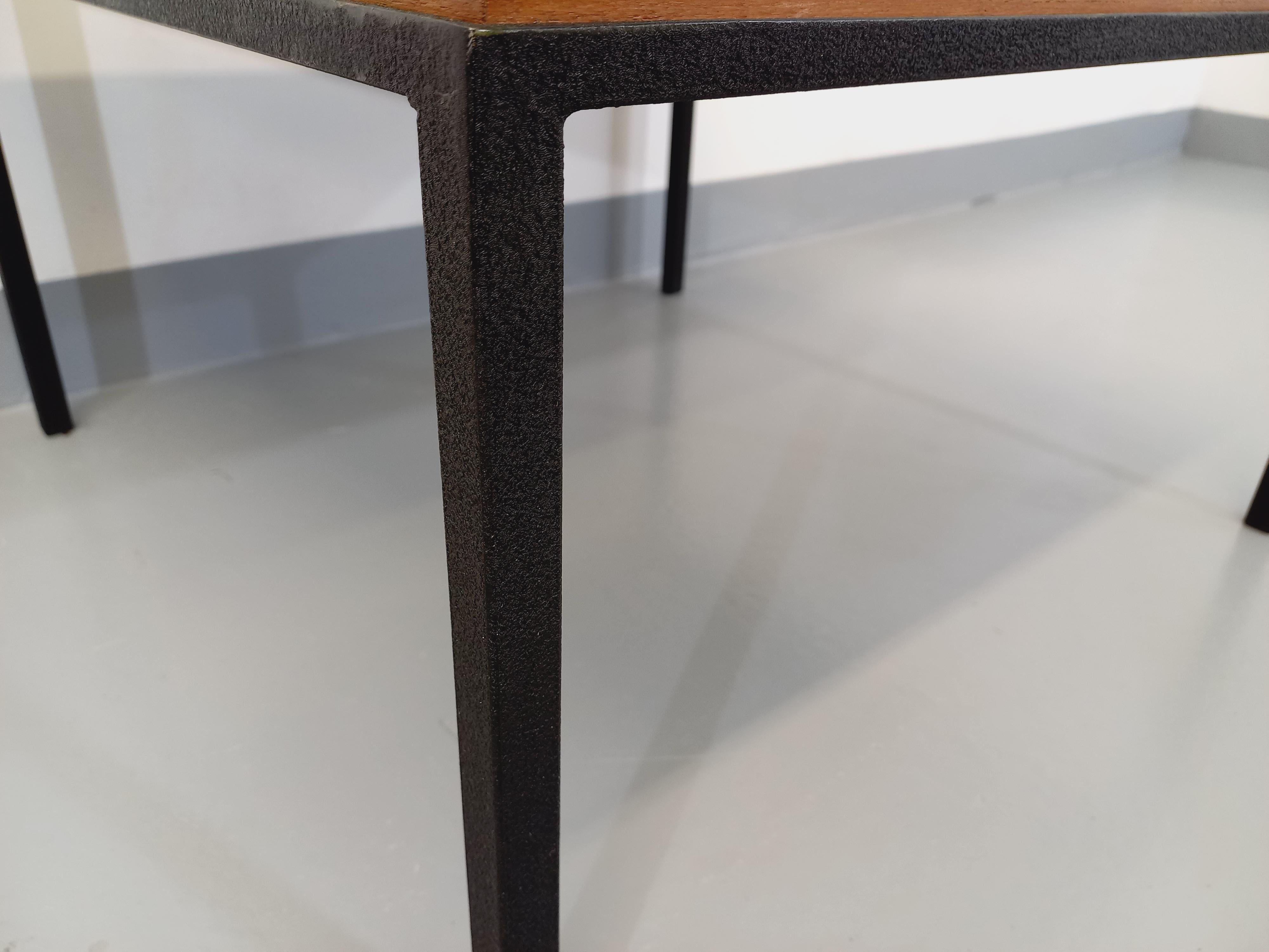 Table basse moderniste vintage des années 60, plateau carré en teck, piétement en métal noir, dans le style des tables de Florence Knoll, Georges Frydman, Wilhelm Renz ou UMP Pastoe par Cees Braakman, très bon état général avec quelques signes du
