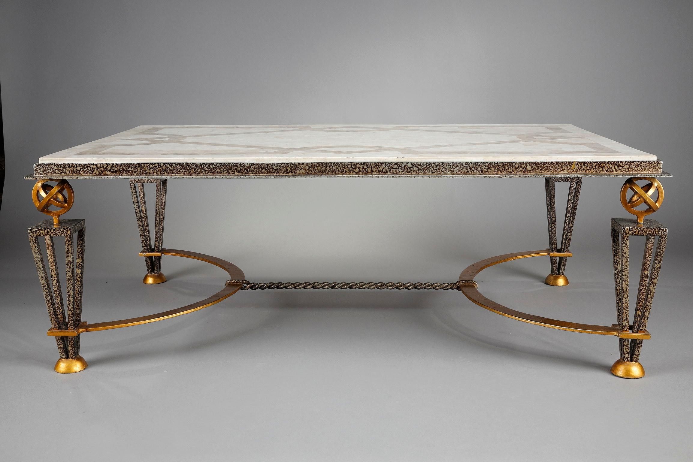 Coffee table in the taste of Gilbert Poillerat in lacquered, oxidized and gilded metal. It rests on four openwork tapered legs with decorative globes on top. The base is joined by a twisted semi-circular crosspiece. The top is composed of a