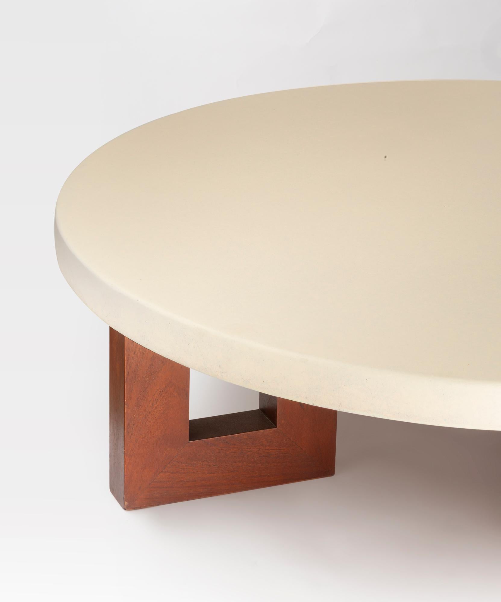 This round coffee table by Paul Frankl combines sculptural elegance with functional design. Its smooth cork top rests on bold geometric wooden legs with open square cutouts, creating a striking play of form and balance. Minimal yet distinctive, it