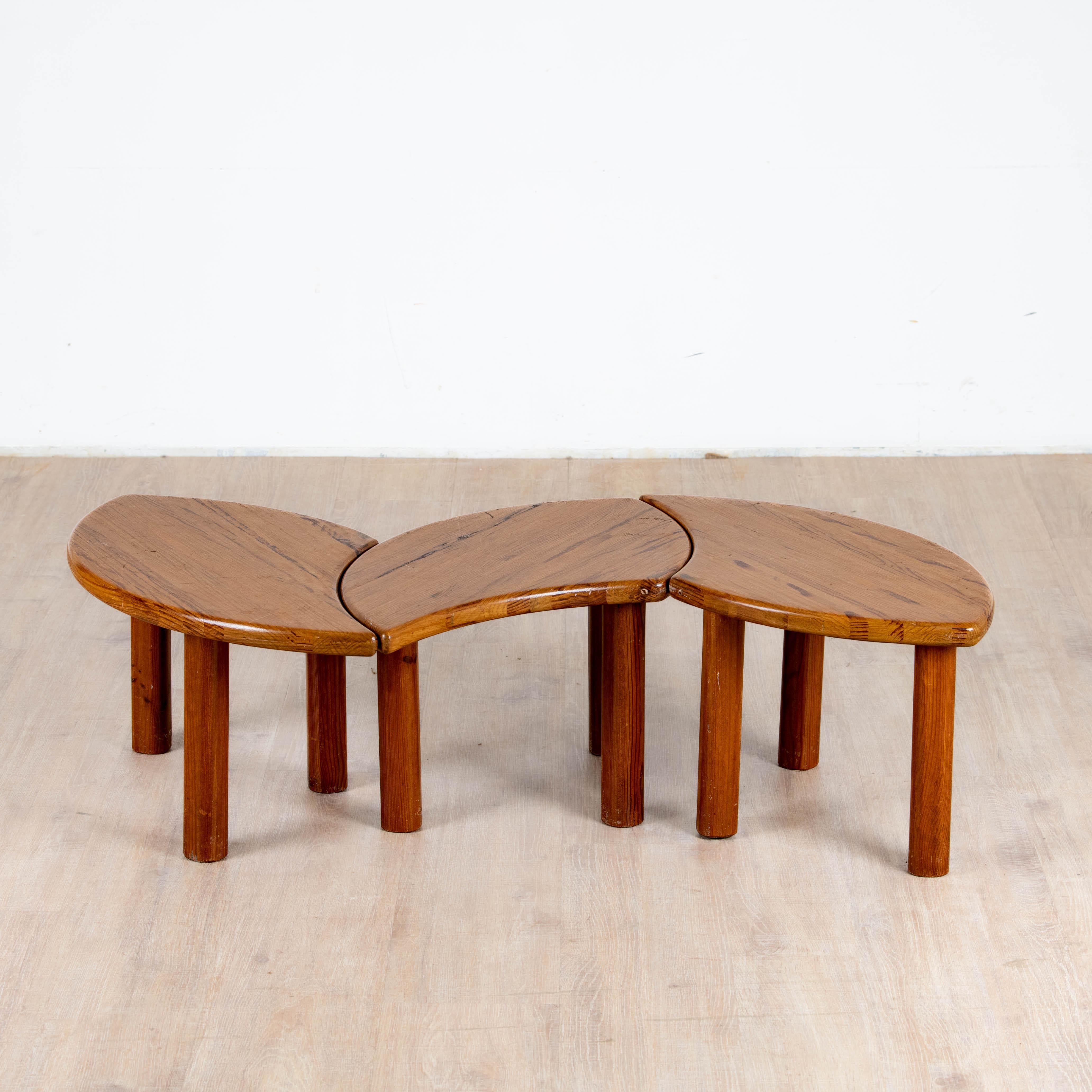 Ensemble de 3 tables basse tripodes modulable en pin travail artisanal des années 1980. Le plateau elliptique, le piètement tripode permettent de créer plusieurs combinaison pour répondre à vos besoins, le pin et sa patine chaleureuse permet