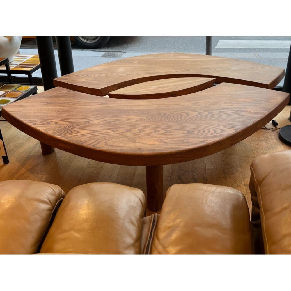 La table en orme massif du designer français Pierre Chapo présente deux plateaux en forme de croissant, avec un 