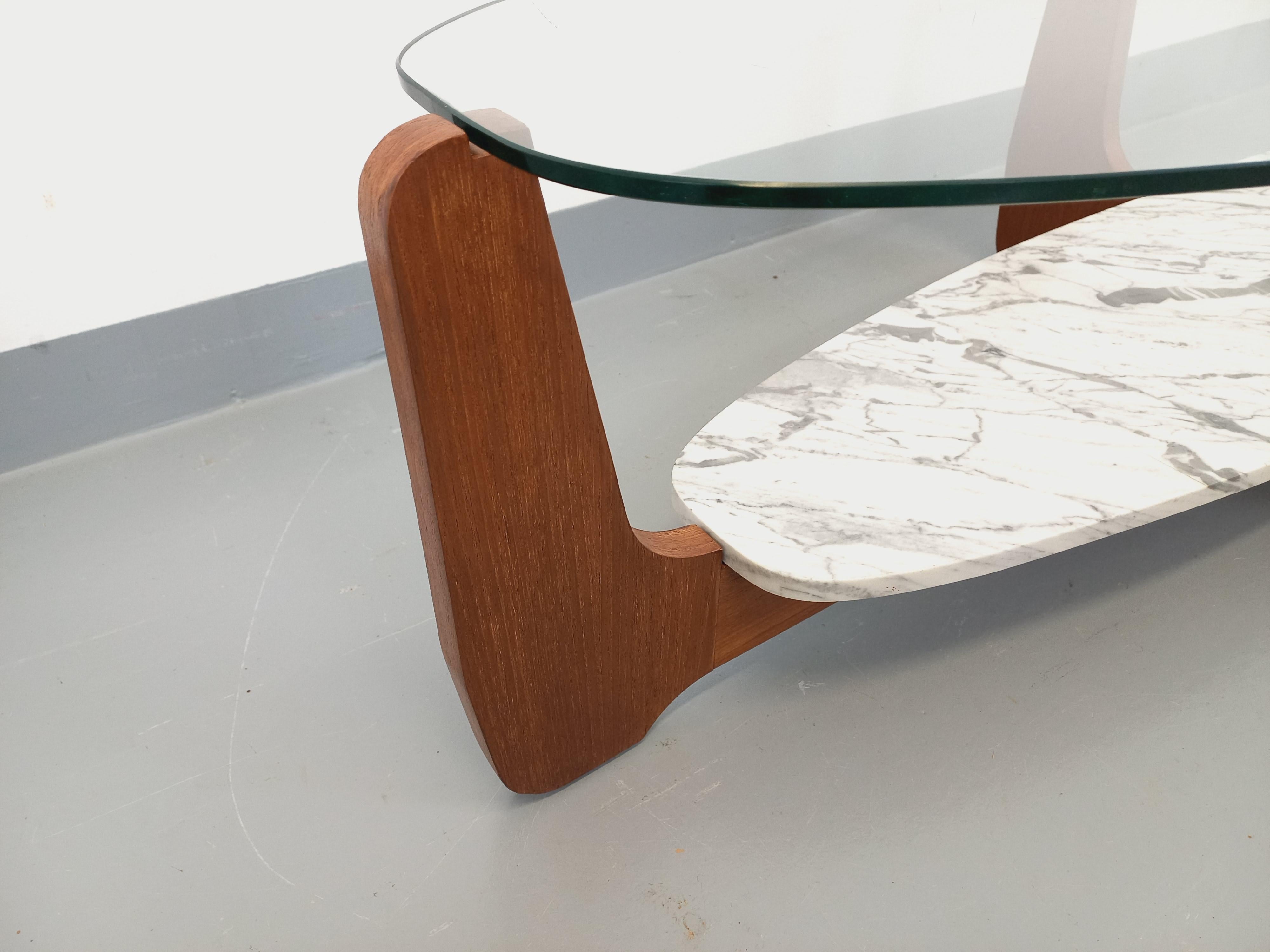 Grande table basse ovale vintage des années 60 70, du designer Hugues Poignant, pied en teck, grand plateau supérieur en verre transparent ovale épais, plateau inférieur porte-revue en marbre blanc de Carrarre au joli veinage gris clair, très beau