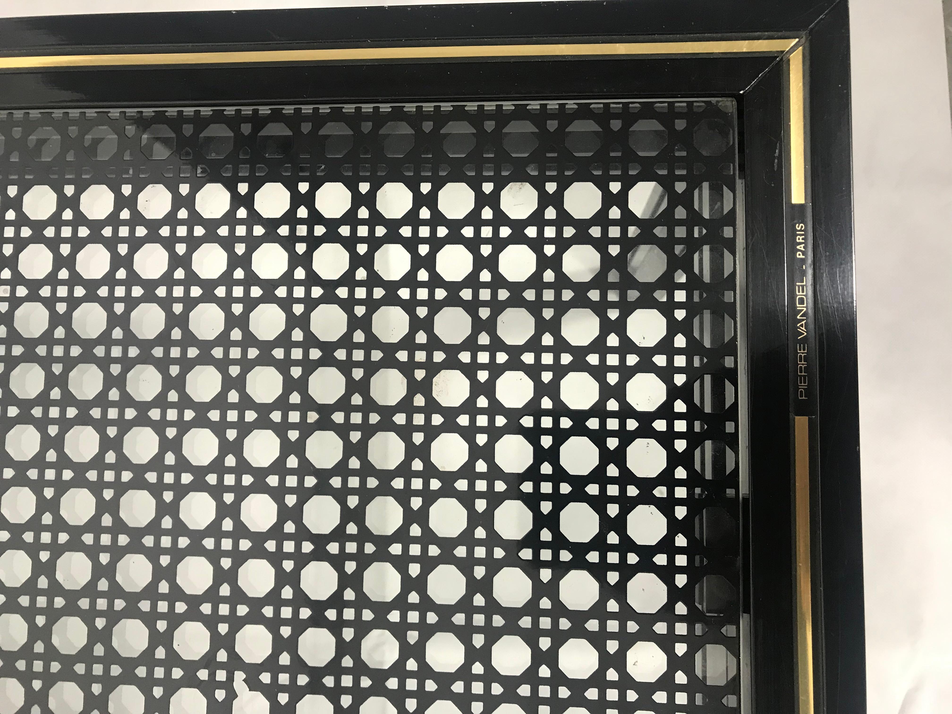 Table basse noire et dorée, signée Pierre Vandel, modèle plutôt rare et iconique, avec le verre à motifs cannage noirs, bon état, quelques traces légères laissé par le temps. Dimensions: Longueur 105, 5 cm. Profondeur 54, 5 cm. Hauteur 33, 5