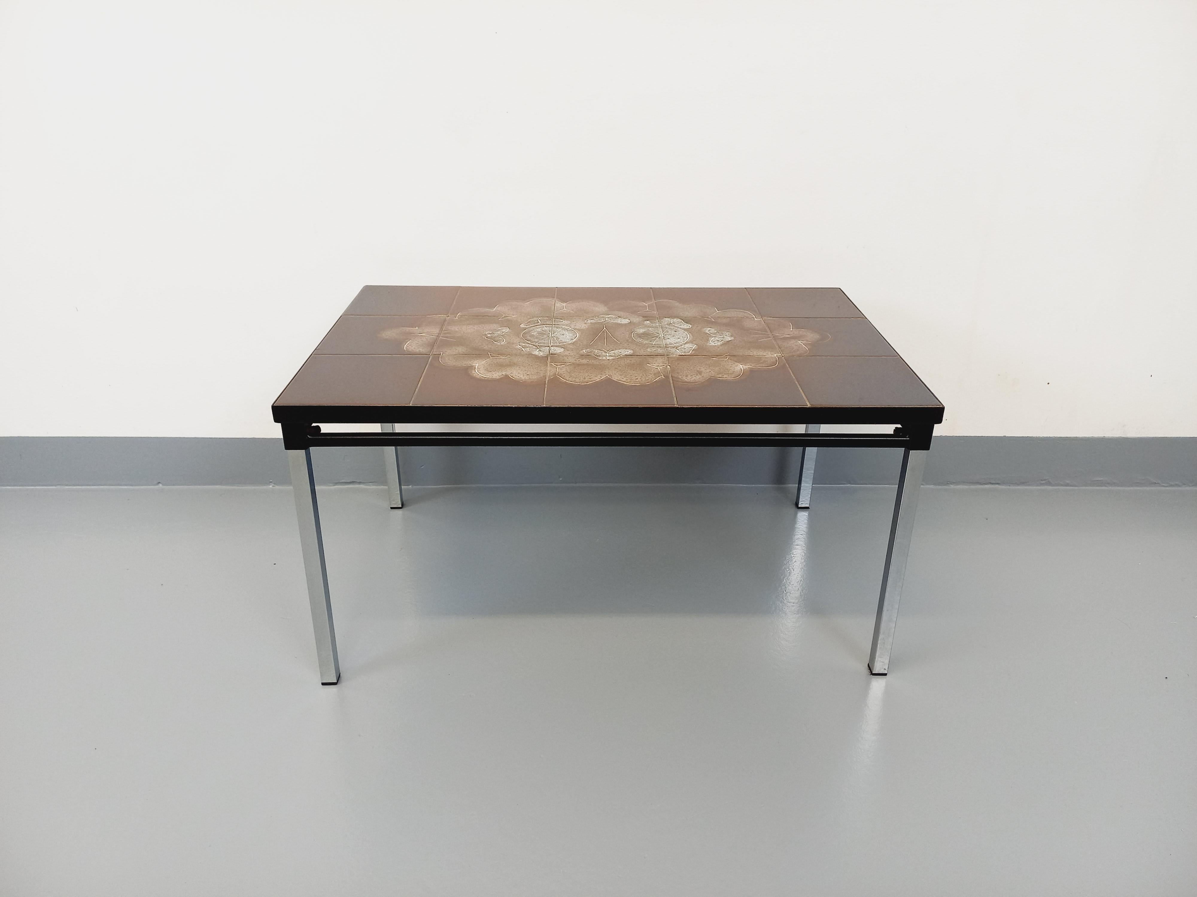 Table basse rectangulaire vintage des années 60 70, plateau rectangle en céramique marron à motifs de papillons, piétement en métal noir et métal chromé, très bon état général avec quelques micro-rayures de surface sur le plateau et quelques signes
