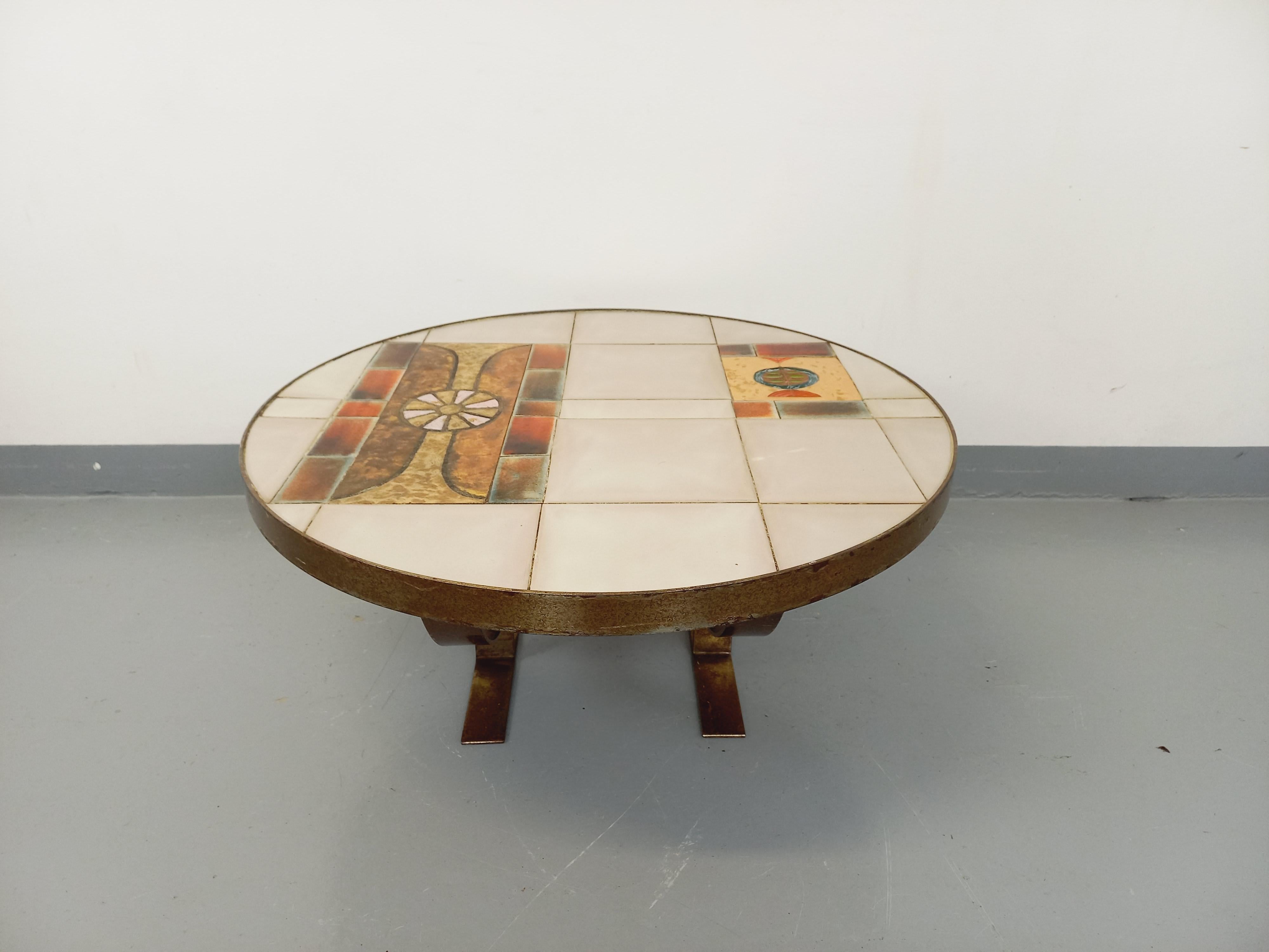 Table basse ronde vintage des années 60 70, design de Jean Gregorieff pour Roche Bobois, modèle Montargis (étiquette encore présente). Plateau en céramique aux motifs abstraits dans les tons blanc crème, écru moiré, orange brique, rose, bleu et