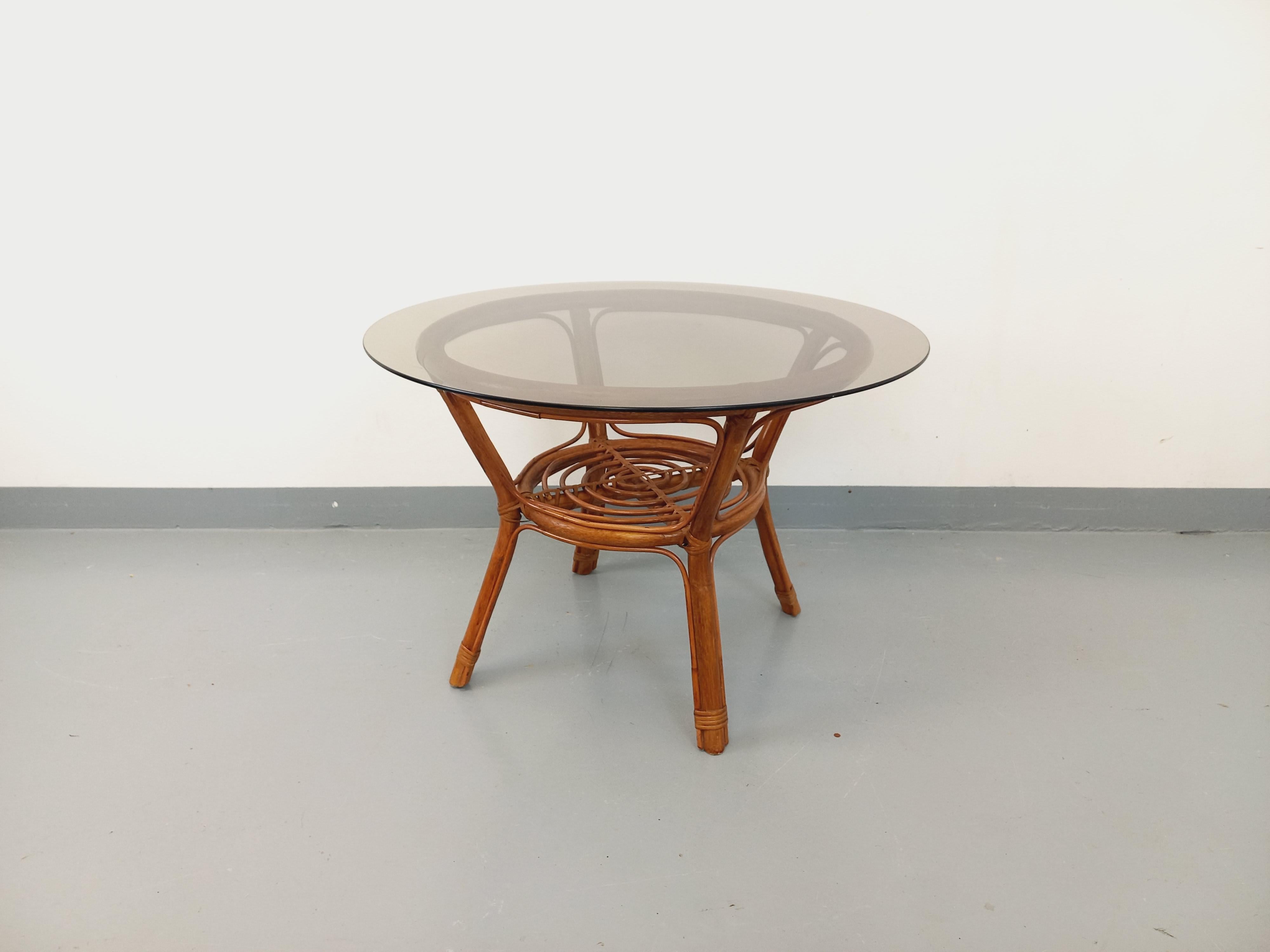 Tavolo basso ronde vintage degli anni '70, in legno e con un look simpatico, 2 piani: piano superiore in vetro fumé e piano inferiore con porte-rivali in legno, très bon état général avec quelques micro-rayures de surface sur le plateau en