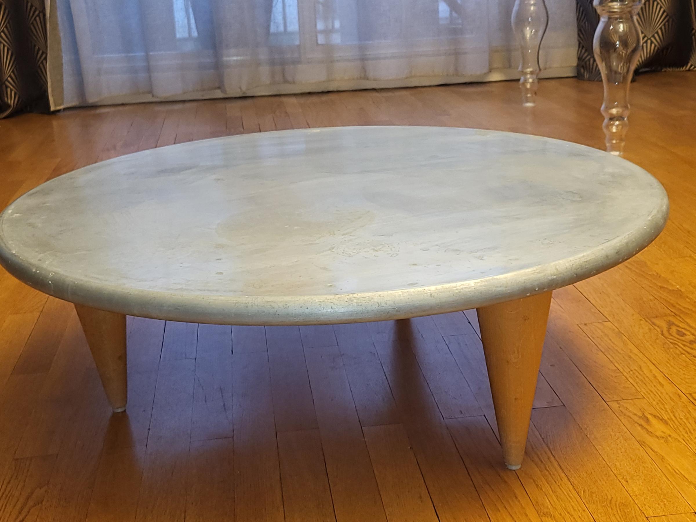 Table basse ronde en plateau zinc repose sur 3 pieds conique en hêtre massif, offrant un design à la fois moderne et intemporel. Elle mesure 80 cm de diamètre et a une hauteur de 26 cm, ce qui en fait une pièce idéale pour une utilisation dans