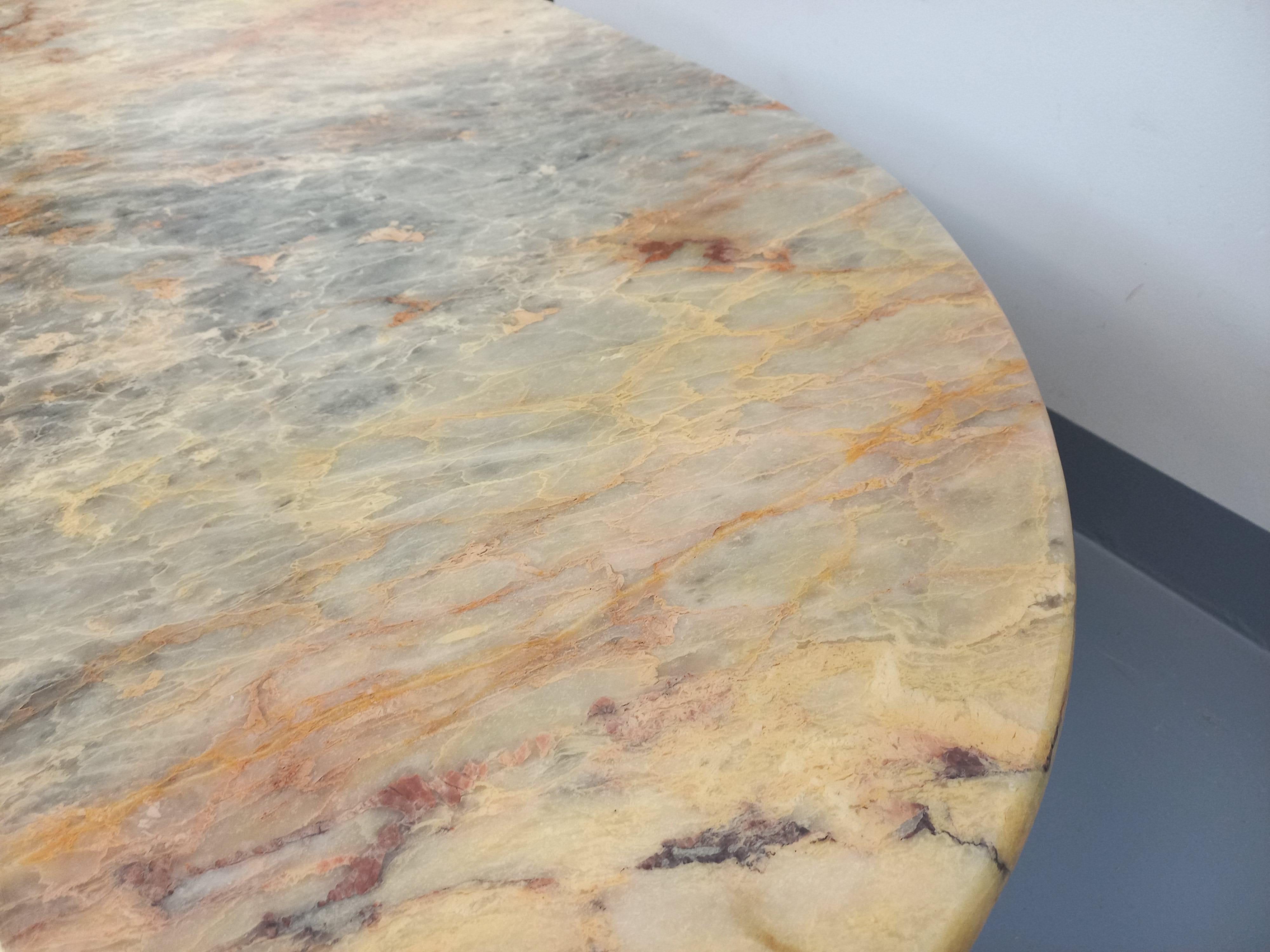 Tavolo basso vintage degli anni '70, in marmo pregiato con un'ottima venatura gris clair, rose saumoné ed écru, forma carrée arrondie su due angoli (o forma d'oeil) e due piedini angolari agli estremi. Un design superbo, probabilmente di Roche