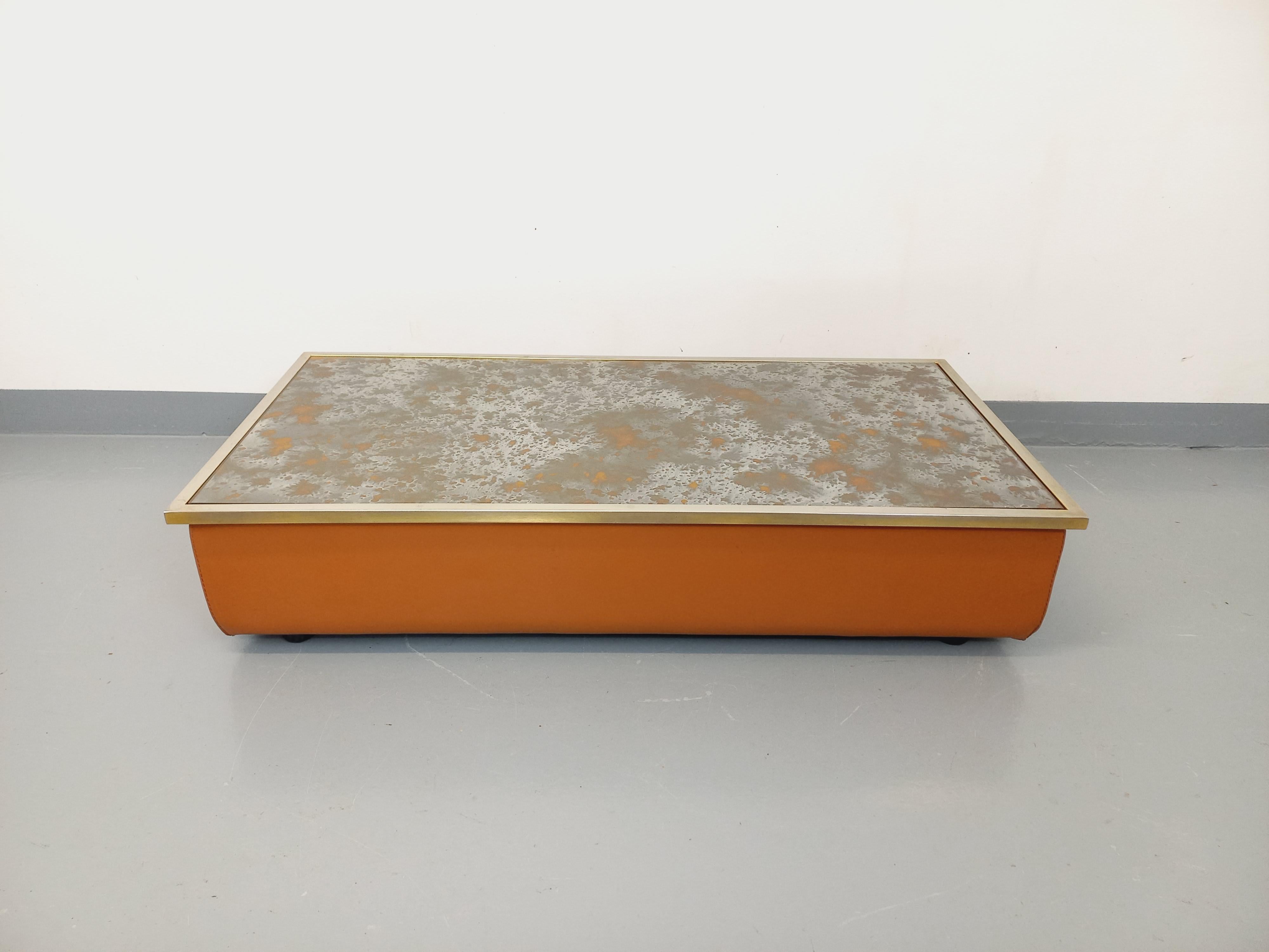 Grande table basse rectangulaire vintage des années 70, très beau design rare et original dans le style De Sede, plateau rectangulaire en métal chromé et verre églomisé à motifs d’éruption solaire aux tons dorés, socle composé d’une plateforme