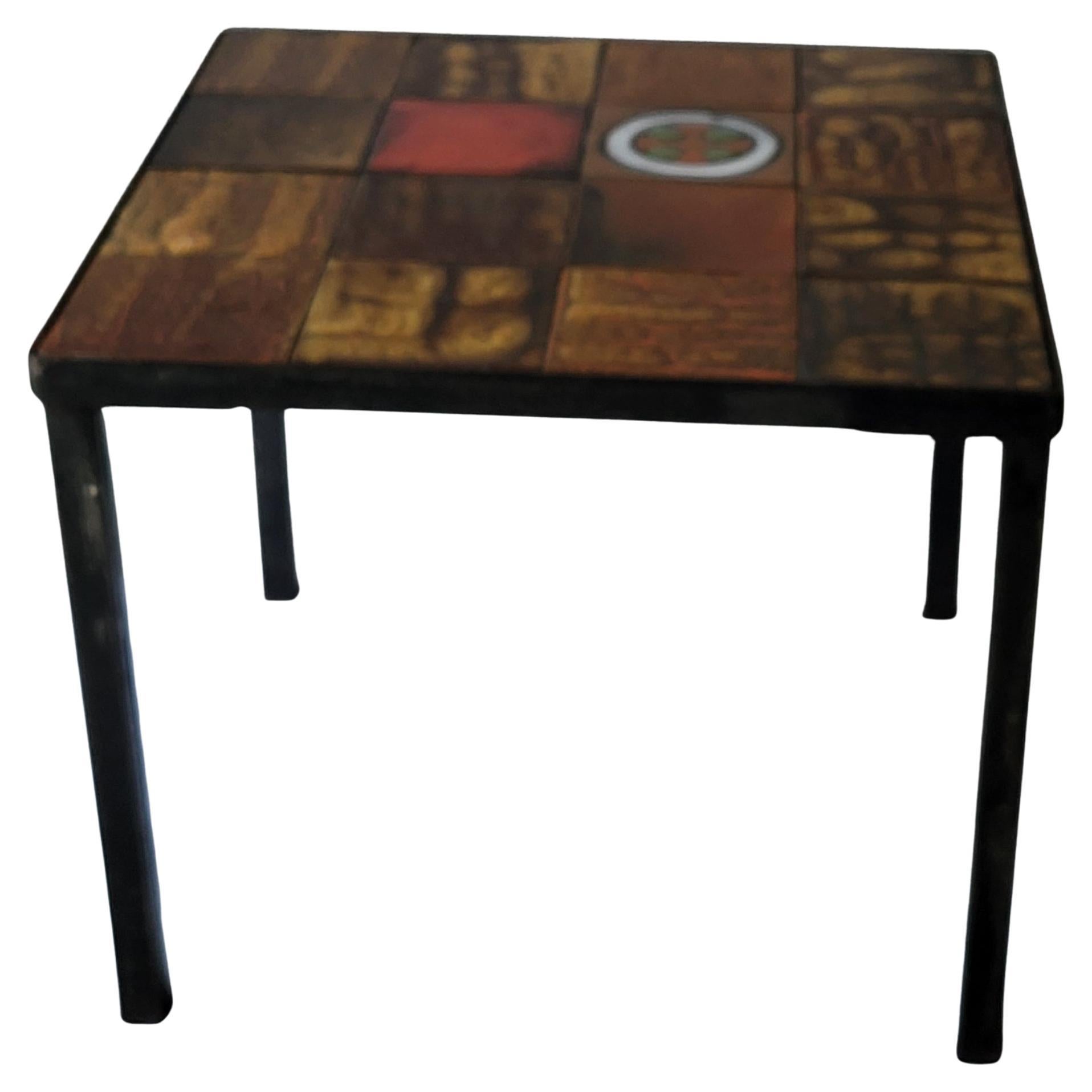 Bout de canapé, fabriqué par Roche Bobois ,  en céramique émaillée aux couleurs chaudes et piétement en métal.
De très grand noms d'artistes céramistes ont designé pour Roche Bobois, comme Jean Gregorieff
Elle se compose de 18 carreaux en très bel