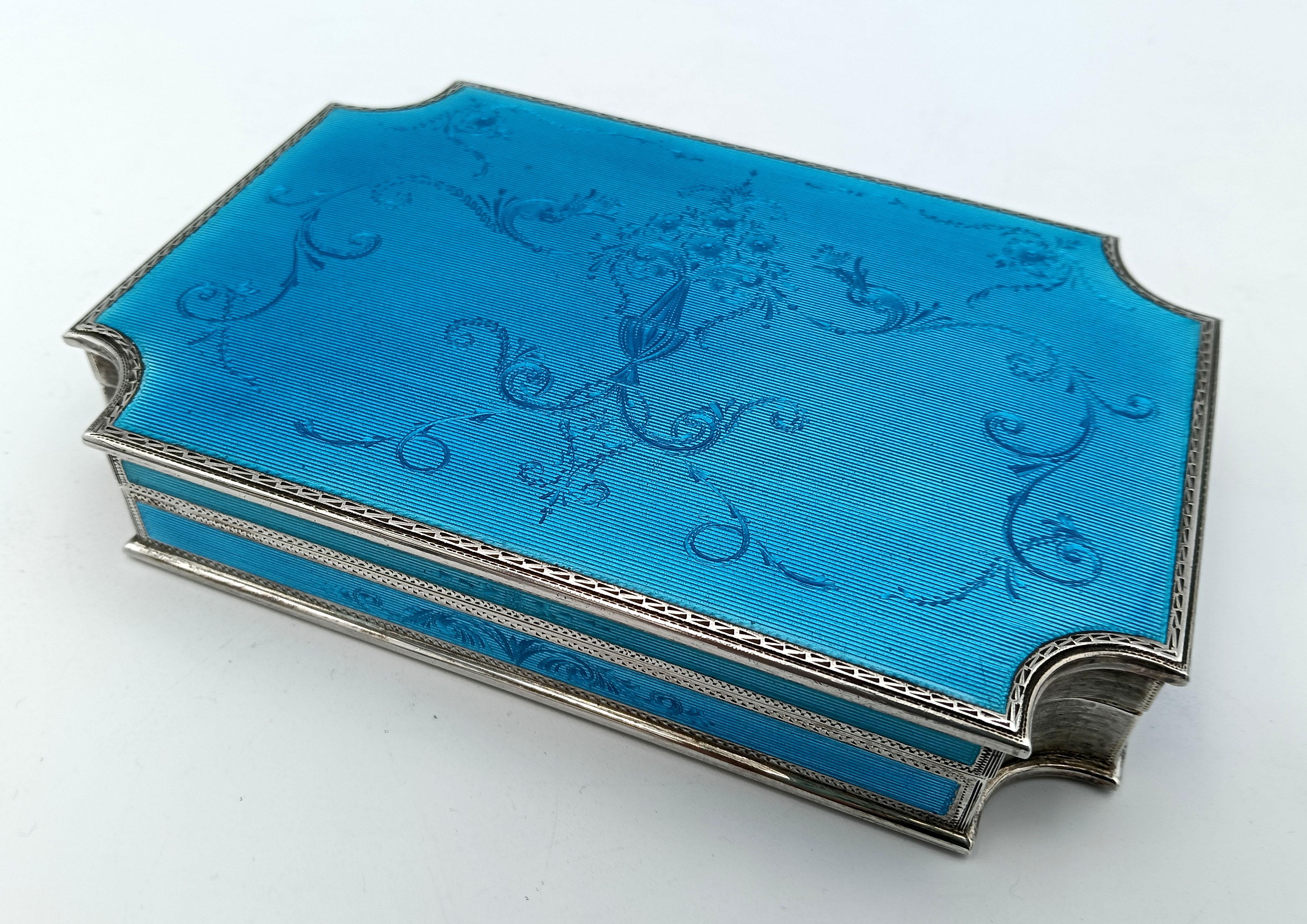 Rectangular table box with concave corners in 925/1000 sterling silver with translucent fired enamel on guilloché, also on the sides and fine hand engravings in baroque style. With lost hinge, i.e. semi-invisible. Finishing with hand-engraved