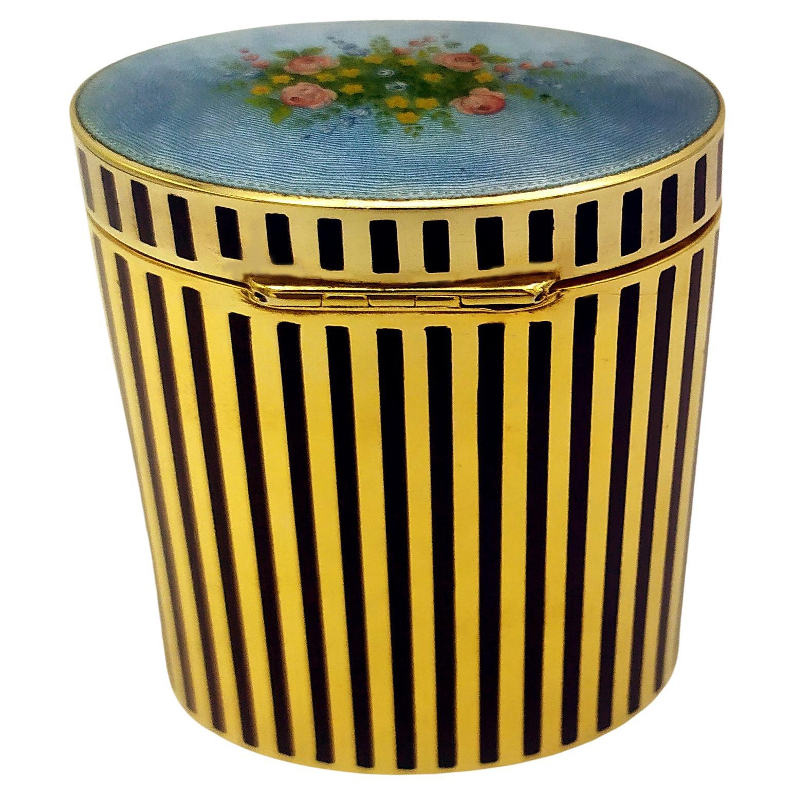 Oval table box in 925/1000 sterling silver gold plated with fired enamel, with fine floral miniature fire-enamelled on guilloche, enamelled edge with vertical stripes. Viennese Art Nouveau style, early 1900s. Dimensions cm. 5.5 x 8 cm height cm. 10.