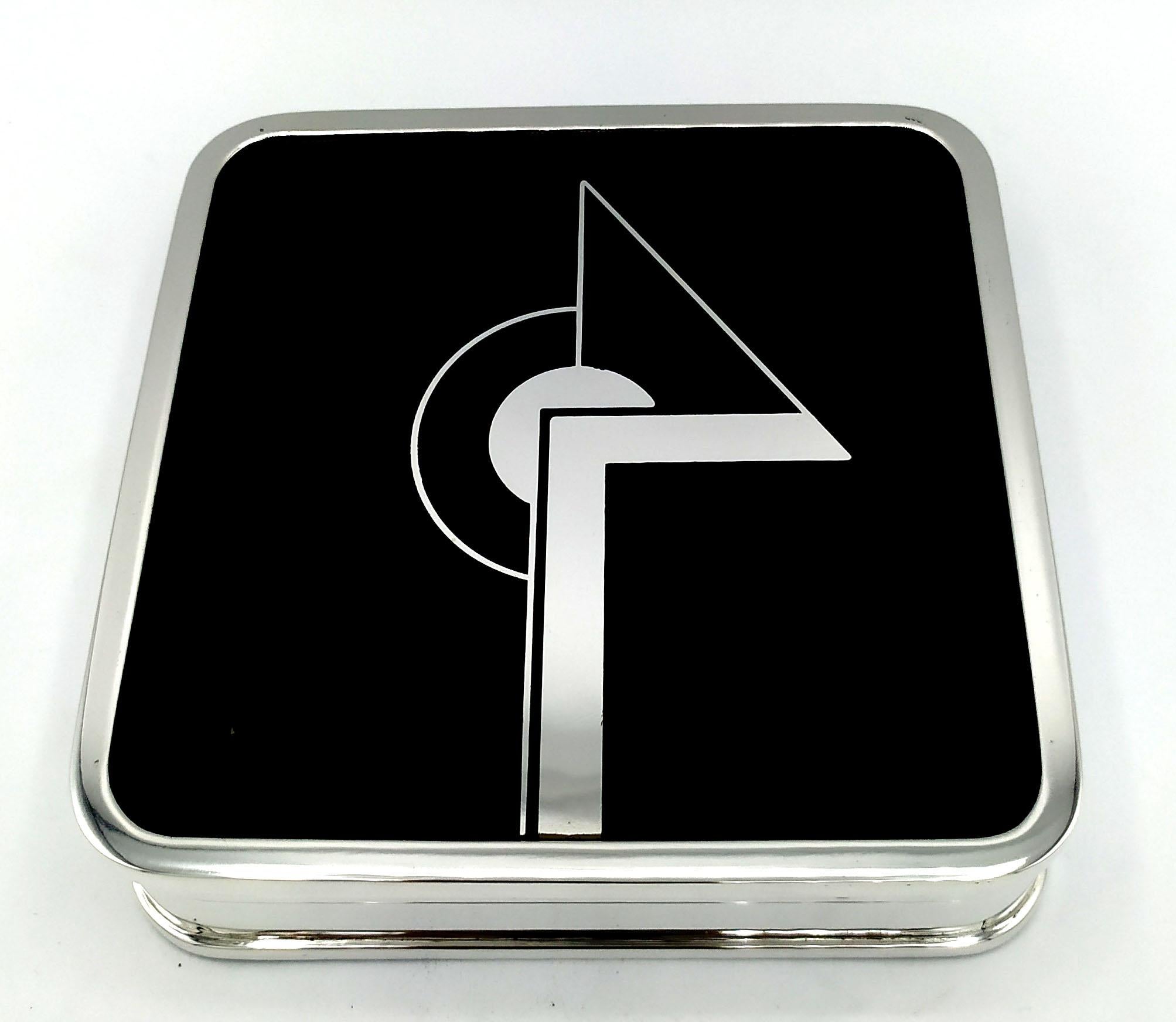 Square table box for cigarettes with rounded corners in 925/1000 sterling silver with black fired enamel. Measure cm. 12.7 x 12.7 x 3.2. Weight gr. 640. Created in the Art Deco style for Cartier USA in the 1980s, inspired by designs by Louis Cartier