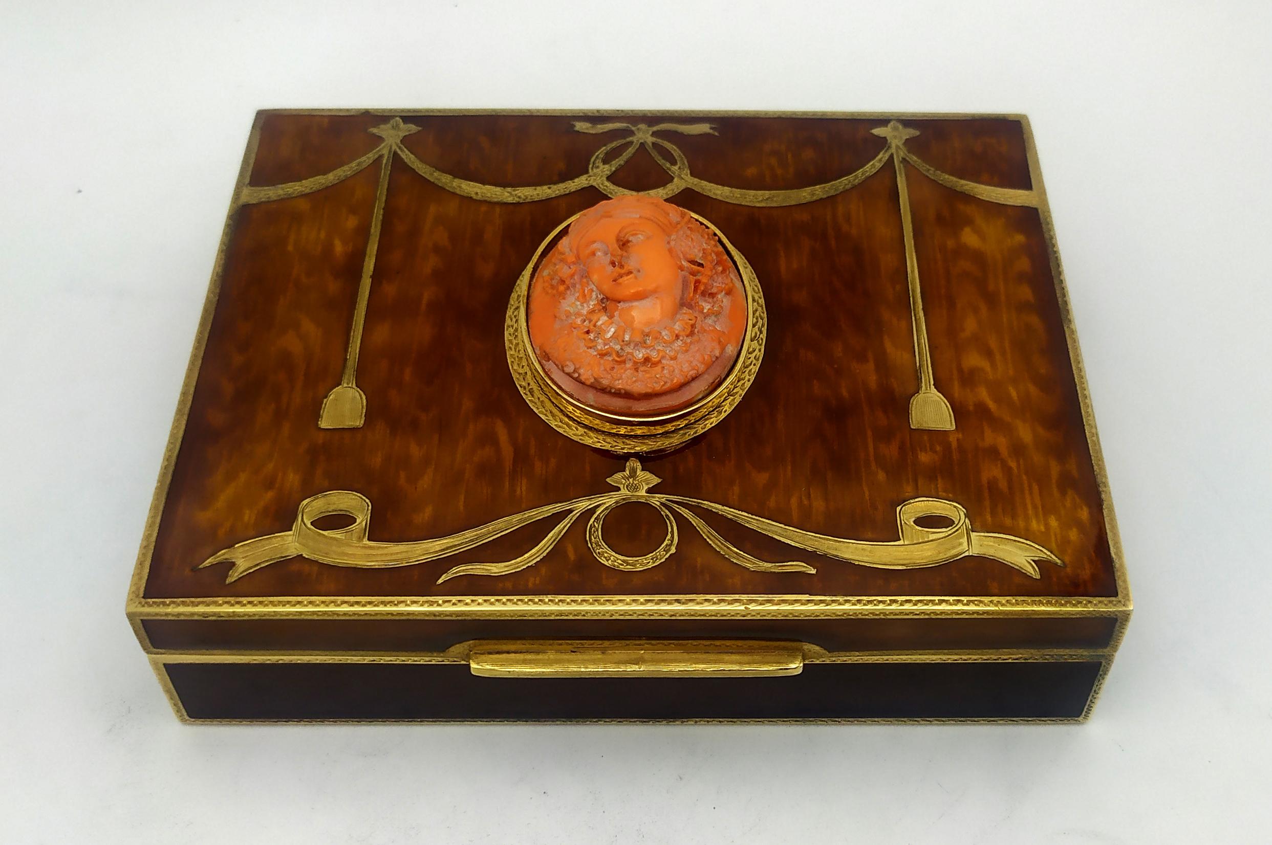 Table Box wood style and Coral is in 925/1000 sterling silver.
Table Box wood style and Coral has transparent brown fired enamel over hand-engraved wood grain.
Table Box wood style and Coral has a large oval coral cm. 3.2 x 4.4 hand engraved of a