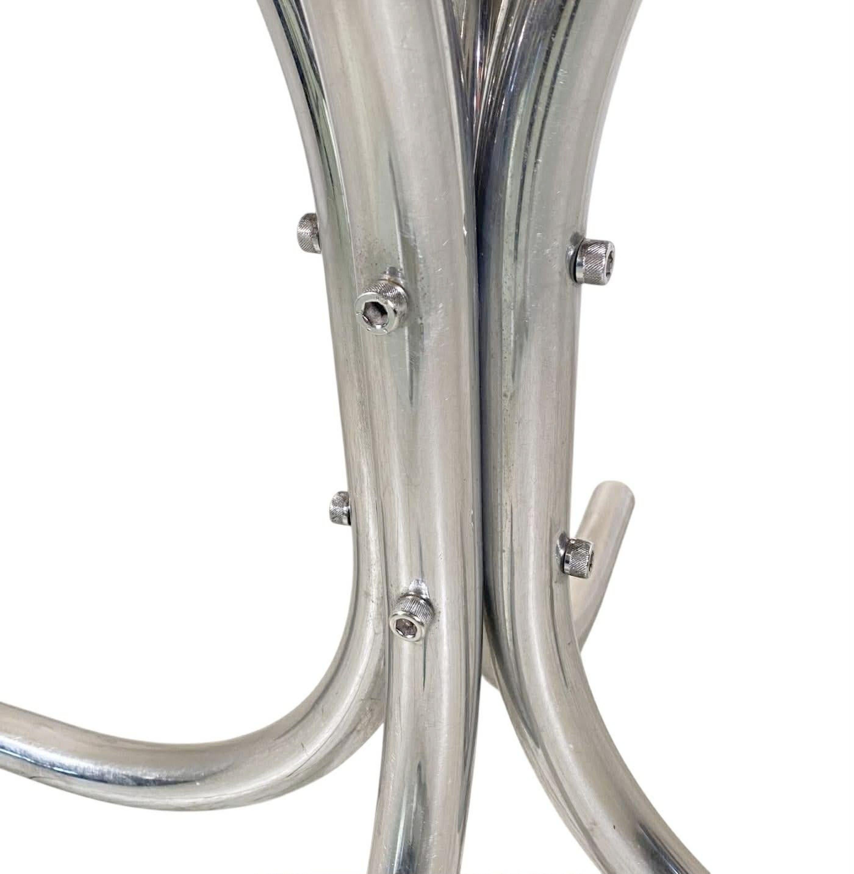 This table exemplifies the sleek modernist aesthetic of 1970s space age Italian design with its minimalist chrome tubular base and smoked glass top .