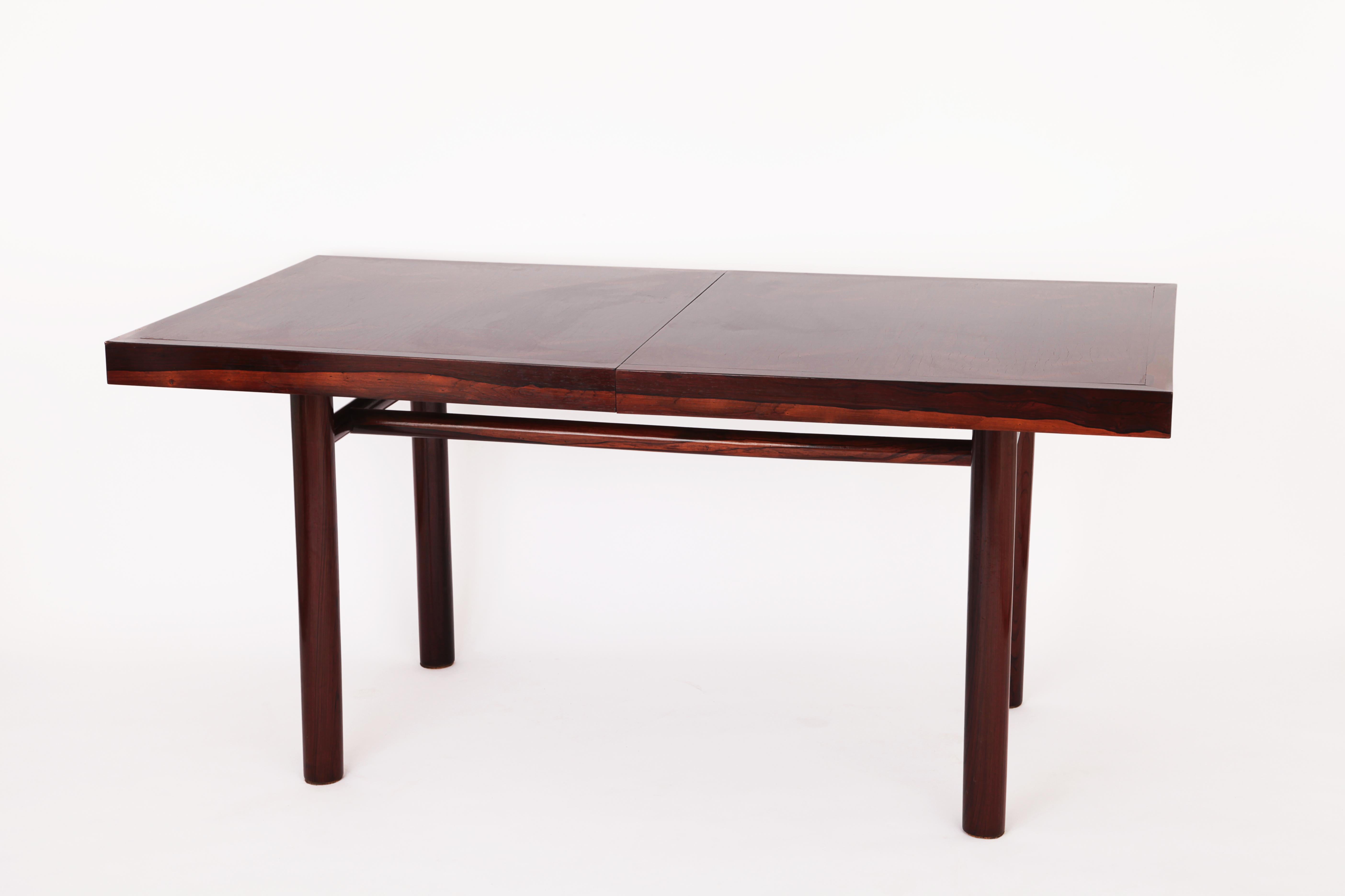 A Dining table by Joaquim Tenreiro made of solid Imbuia with beautiful grain and veins.
A wide solid wood border underlines the modernity of the lines.

The table can be use as a desk du to her size or console. 

There are 2 extensions (2x36