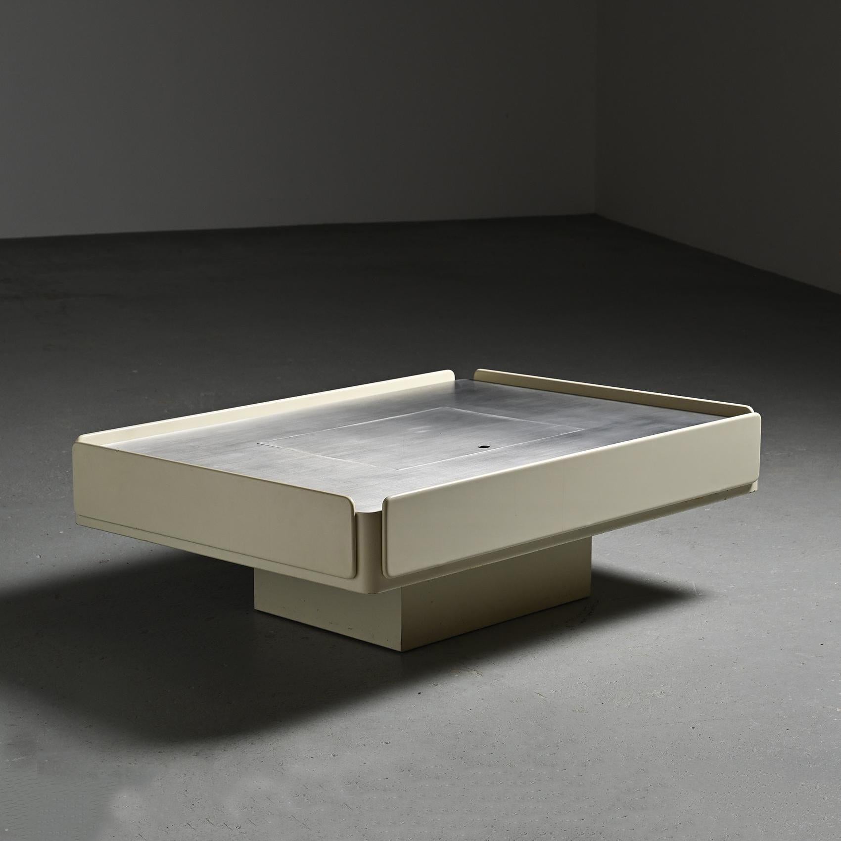 
A coffee table known as the Caori model, envisioned by Italian designer Vico Magistretti in the 1960s.

The structure, crafted from white lacquered wood, elegantly houses a spacious rectangular aluminum tabletop. This tabletop is adorned with a
