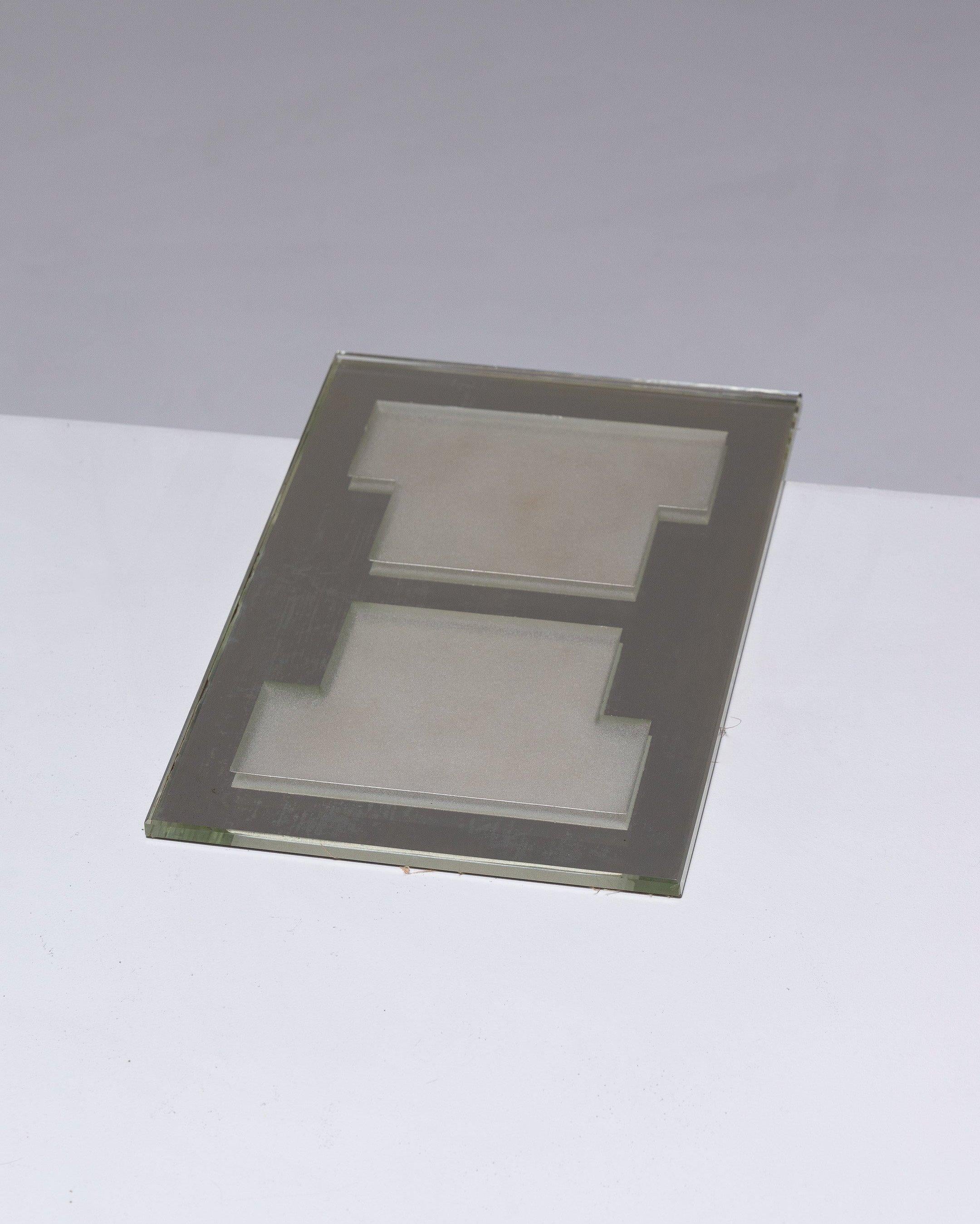 Assiette centrale de table de Jean Luce, dans le style art déco des années 1930. Fabriqué en verre rectangulaire épais et biseauté. Base réfléchissante en miroir et gravures géométriques sur fond granité opaque créé par sablage. En bon état.
DV1408