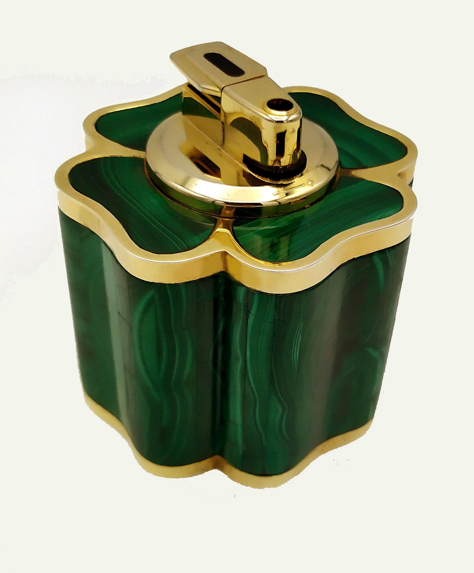 Table cigar lighter in the shape of a four-leaf clover with frames in 925/1000 sterling silvergold plated and real malachite stone. Piezoelectric mechanism. Dimensions cm. 8 x 8 cm high. 7. Silver weight gr. 54. Designed by Giorgio Salimbeni in 1975
