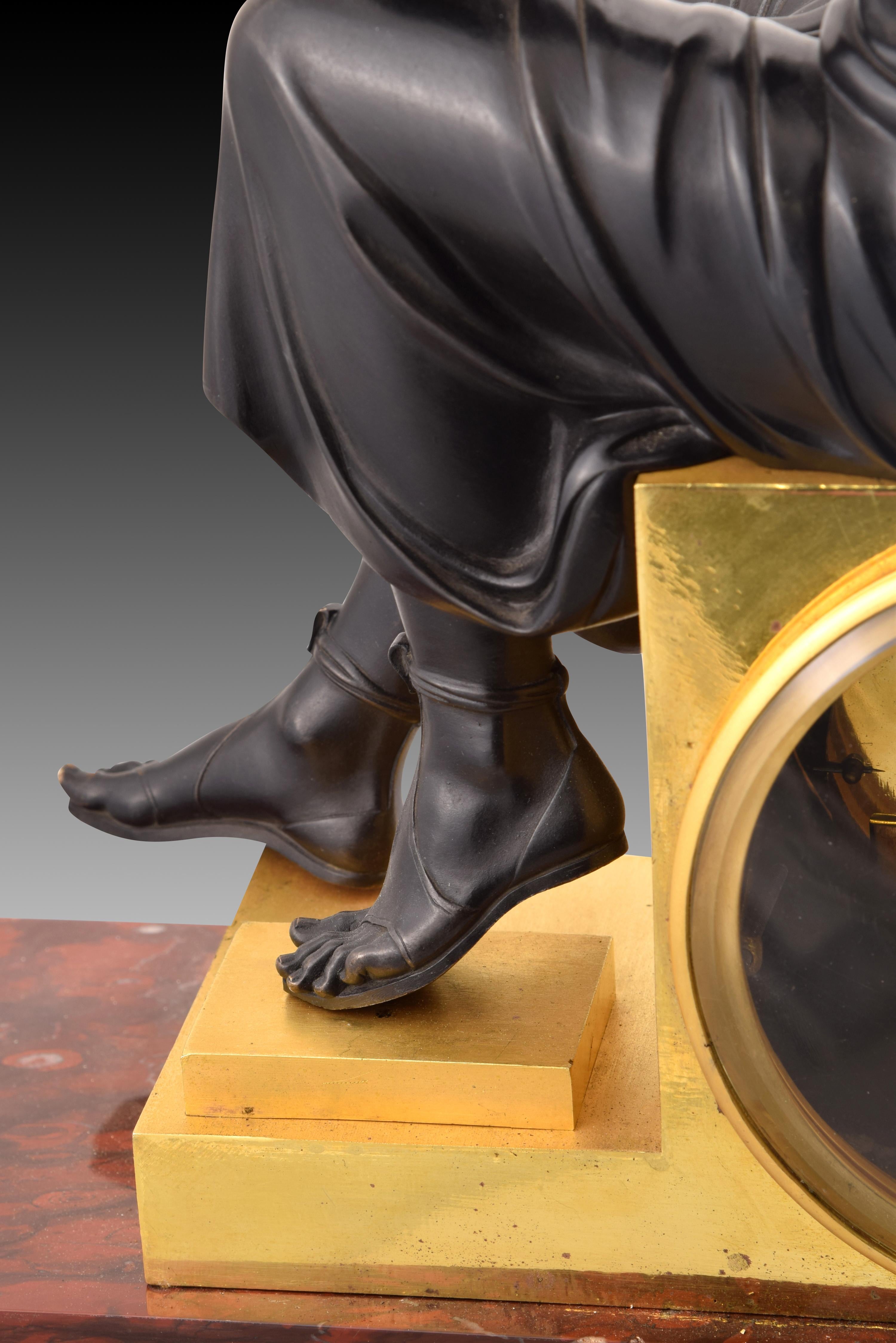 Tischuhr, Apollo. Bronze, Marmor. Modell von Lenoir-Ravrio, Louis-Stanislas(1783-1846). Paris, um 1820. 
Tischuhr, bestehend aus einem gestaffelten rechteckigen Sockel aus rot geädertem Marmor und mit vergoldeten Bronzeelementen mit deutlichem