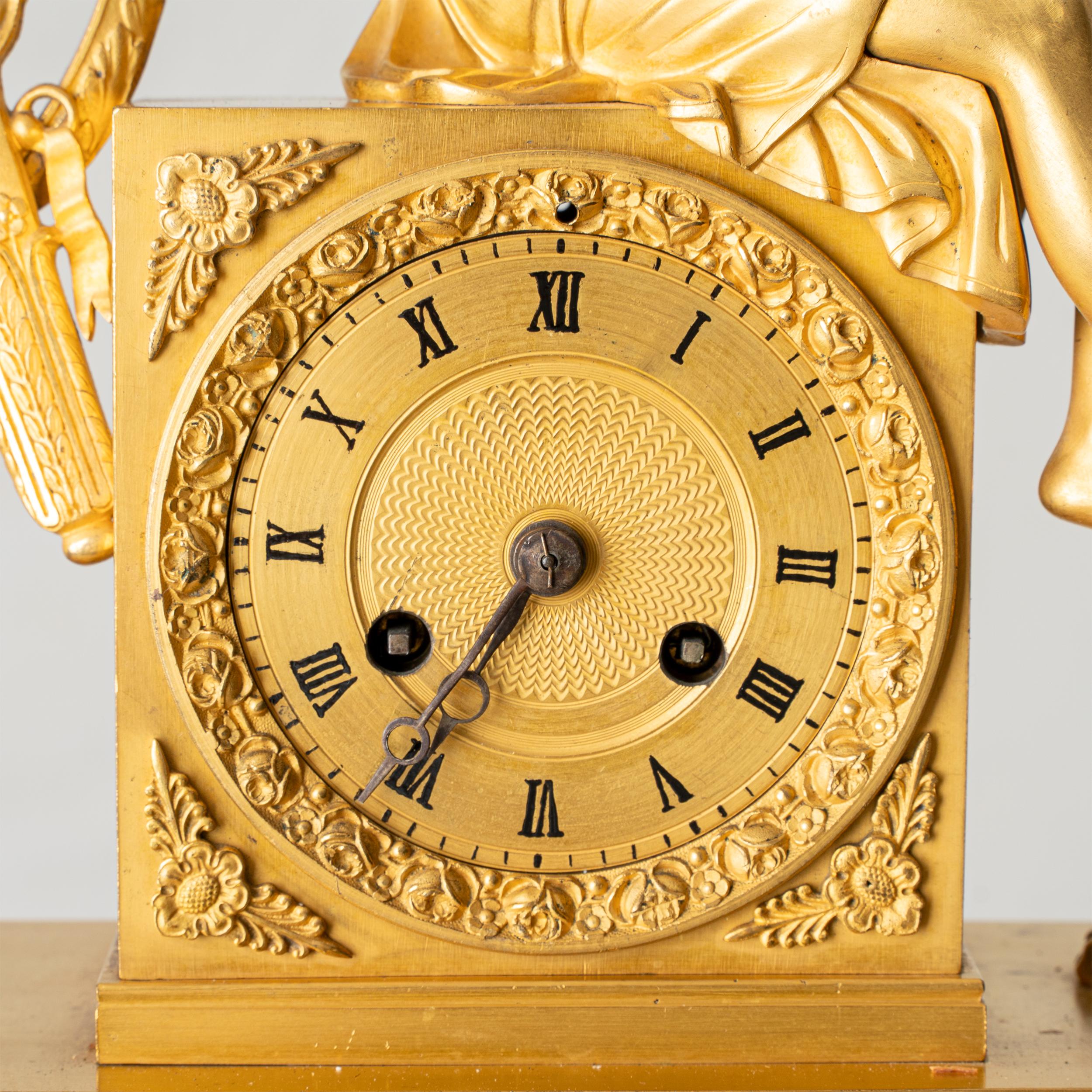 Pendule de cheminée fabriquée en France sous l'Empire, entre 1790 et 1820. Fabriqué en bronze doré bruni. Le dieu grec Apollo joue de la lyre, ses pieds reposant sur un tabouret doré.