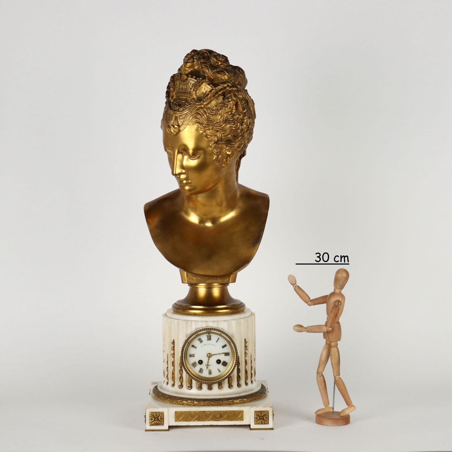 Ferdinand Barbedienne table clock in white marble and gilt bronze. The clock is set inside a fluted column in white marble and rests on a square base. The gilt bronze decorations are with vegetable and Greek motifs and a laurel wreath surrounds the