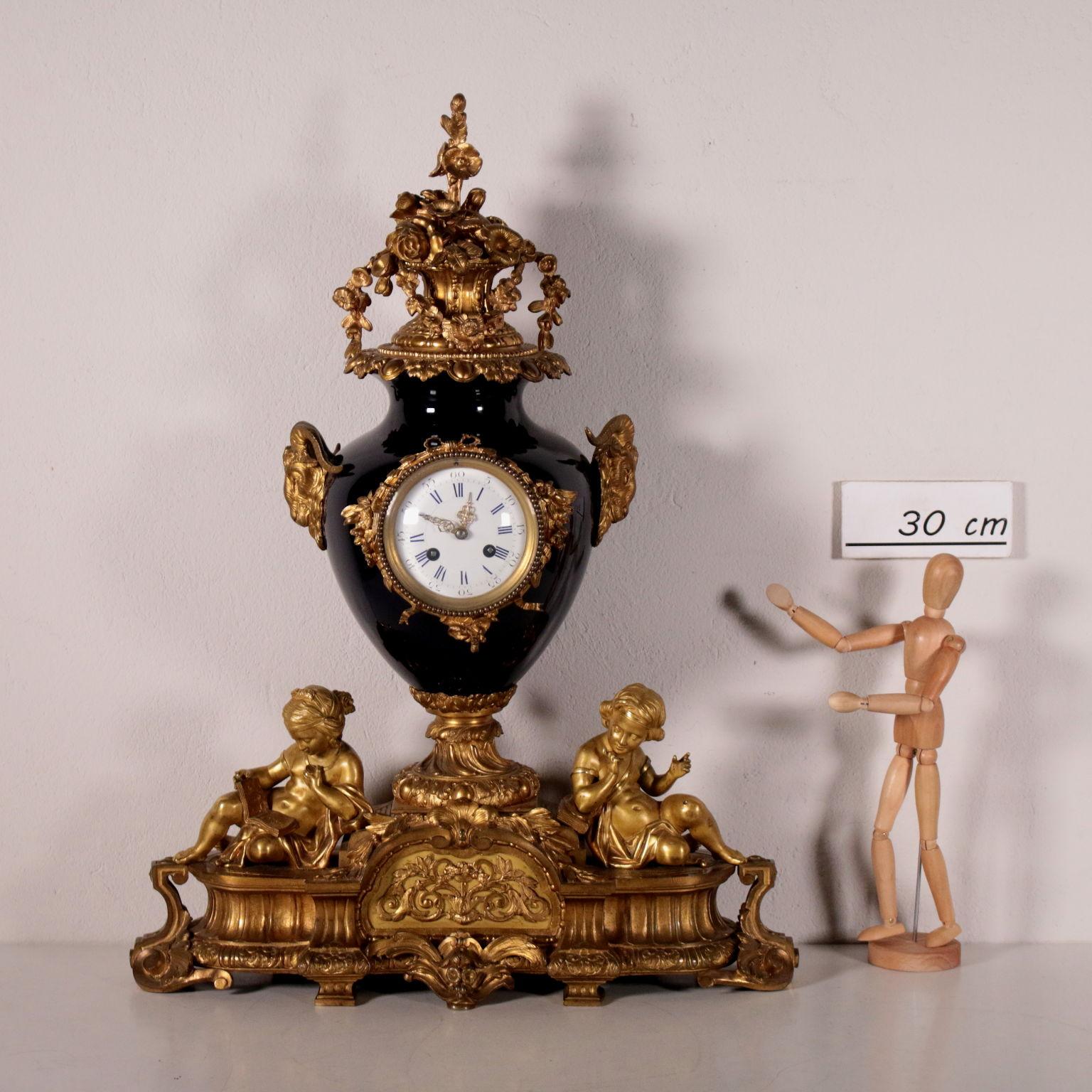 Chiseled gilded bronze clock. On the base there are decorations with plants motifs and leaves-like spirals; on the central reserve there are pierced bronze applications of branches, leaves and a basket of fruit. On the sides there are all-round