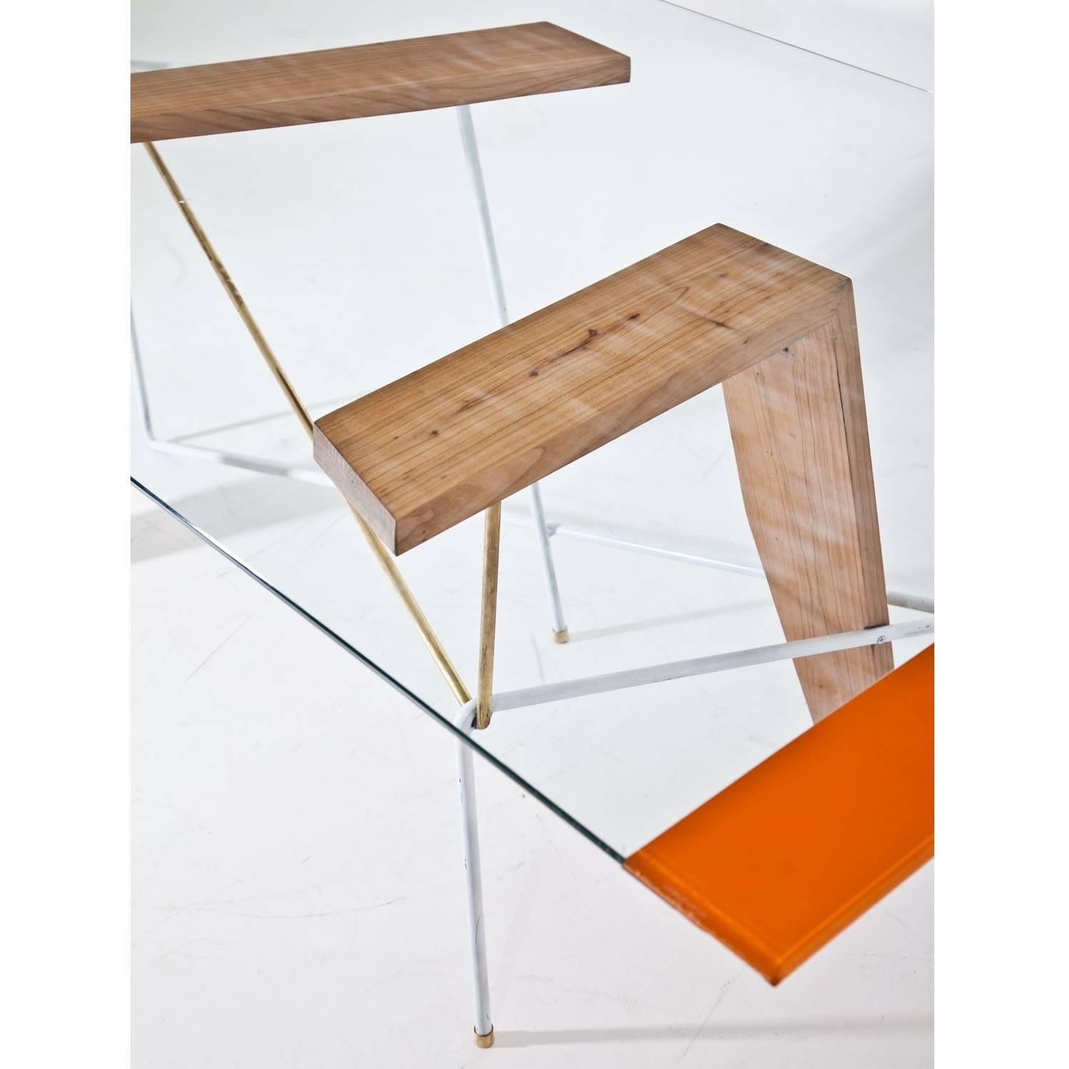 Large table with an extraordinary base out of wood, brass and metal by Mordecai Pillant. The rectangular glass tabletop with an orange strip, labeled “Croazia 20”.