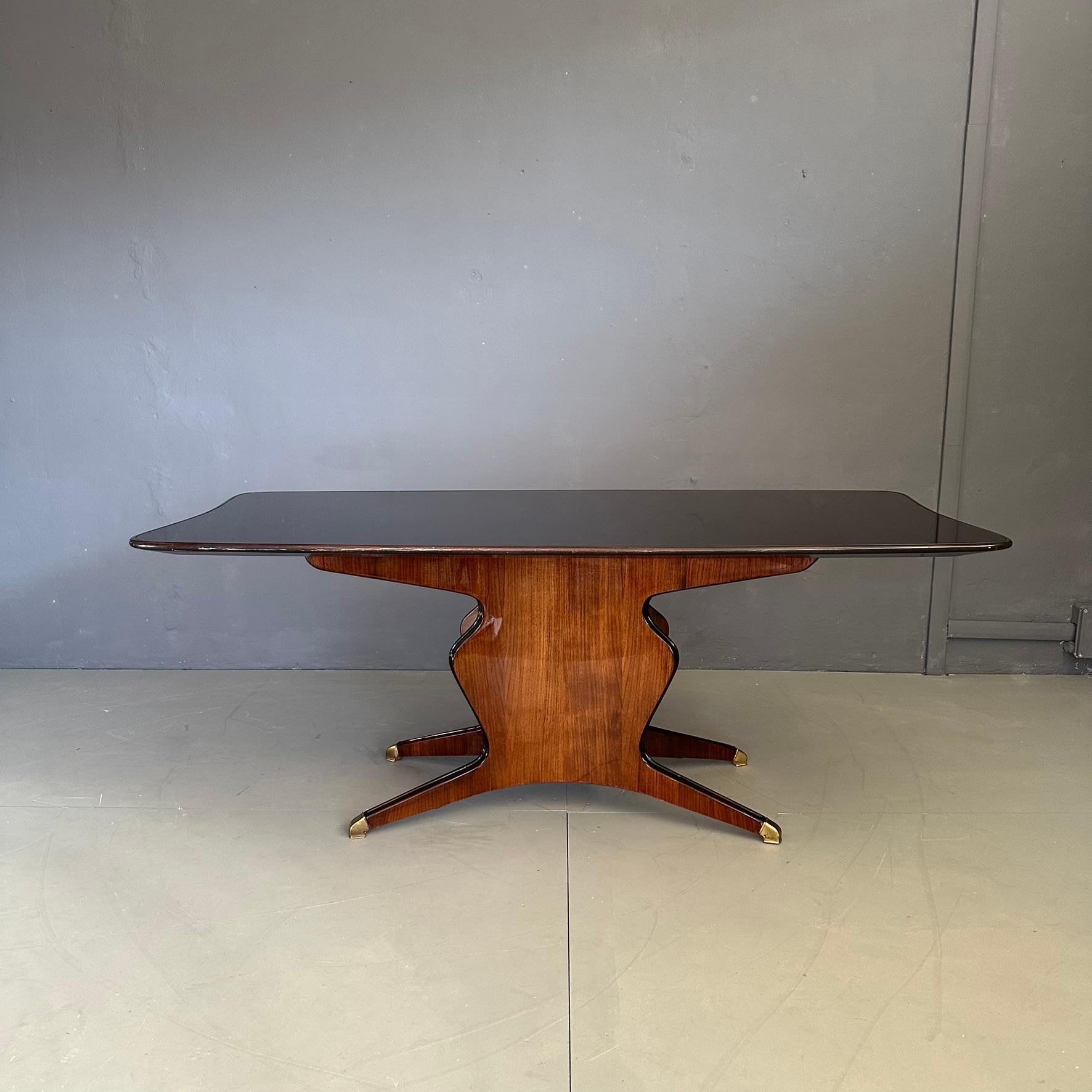 Table de salle à manger conçue par Osvaldo Borsani, produite par Fossati Attilio&Arturo à partir des années 1950.
Sa structure se caractérise par une forme unique et élégante, finie par des pieds en laiton.
Plateau en verre noir brillant qui