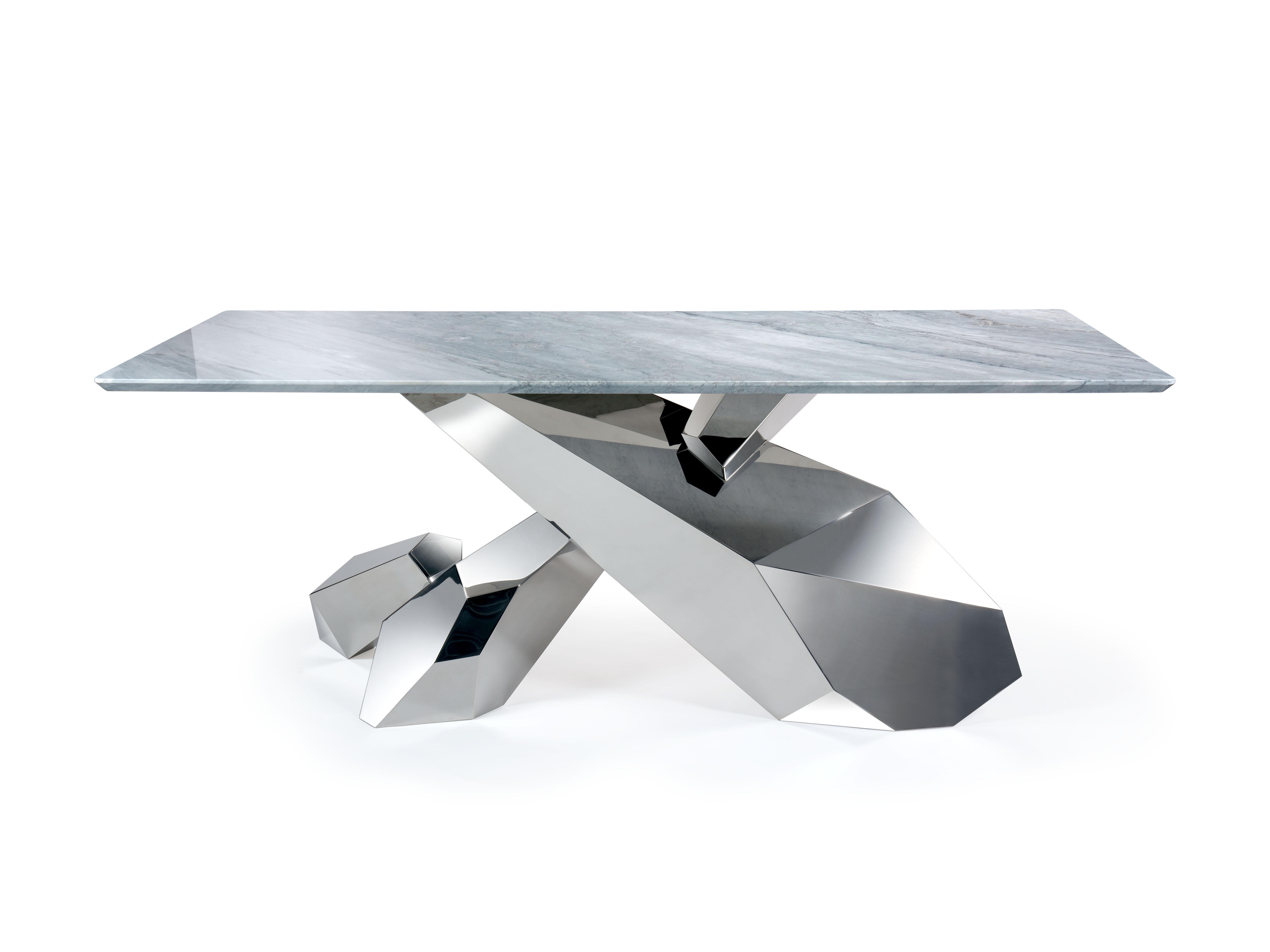 La table 'Steele' est un bureau important avec une structure en acier inoxydable poli miroir et un plateau en marbre gris Versylis. La structure s'inspire d'une formation de cristaux de Gallium et est réalisée entièrement à la main, de la soudure au